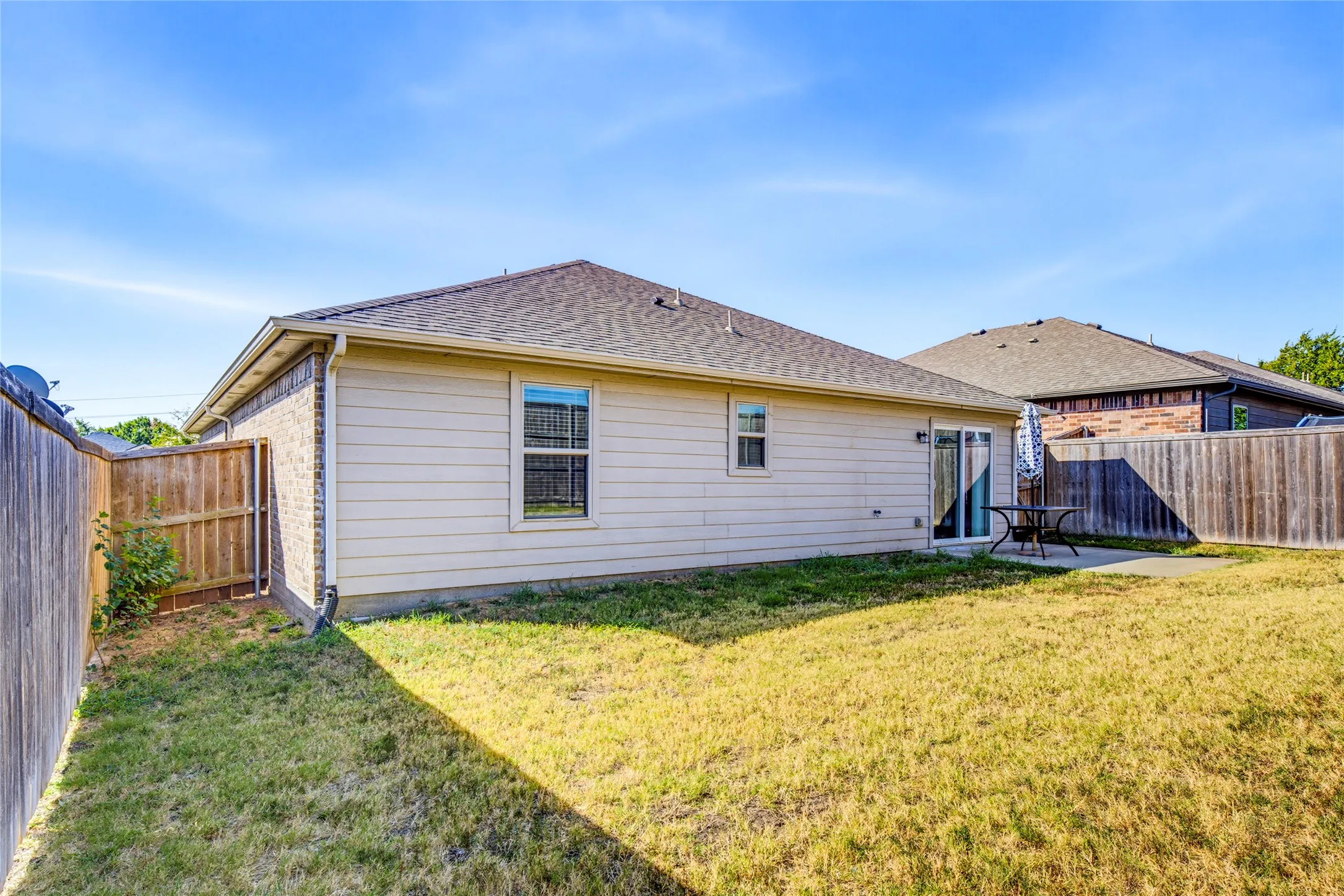 Private backyard with a concrete patio and full perimeter fencing