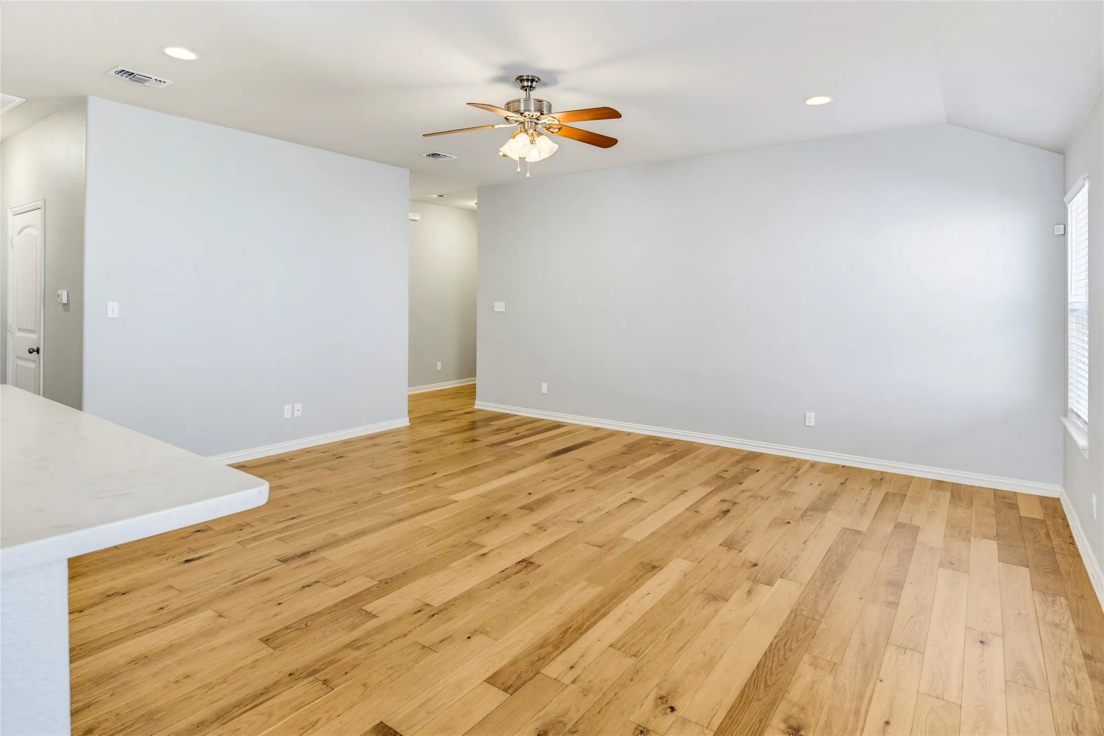 Wood-finish flooring, recessed lighting, and a ceiling fan with light fixture