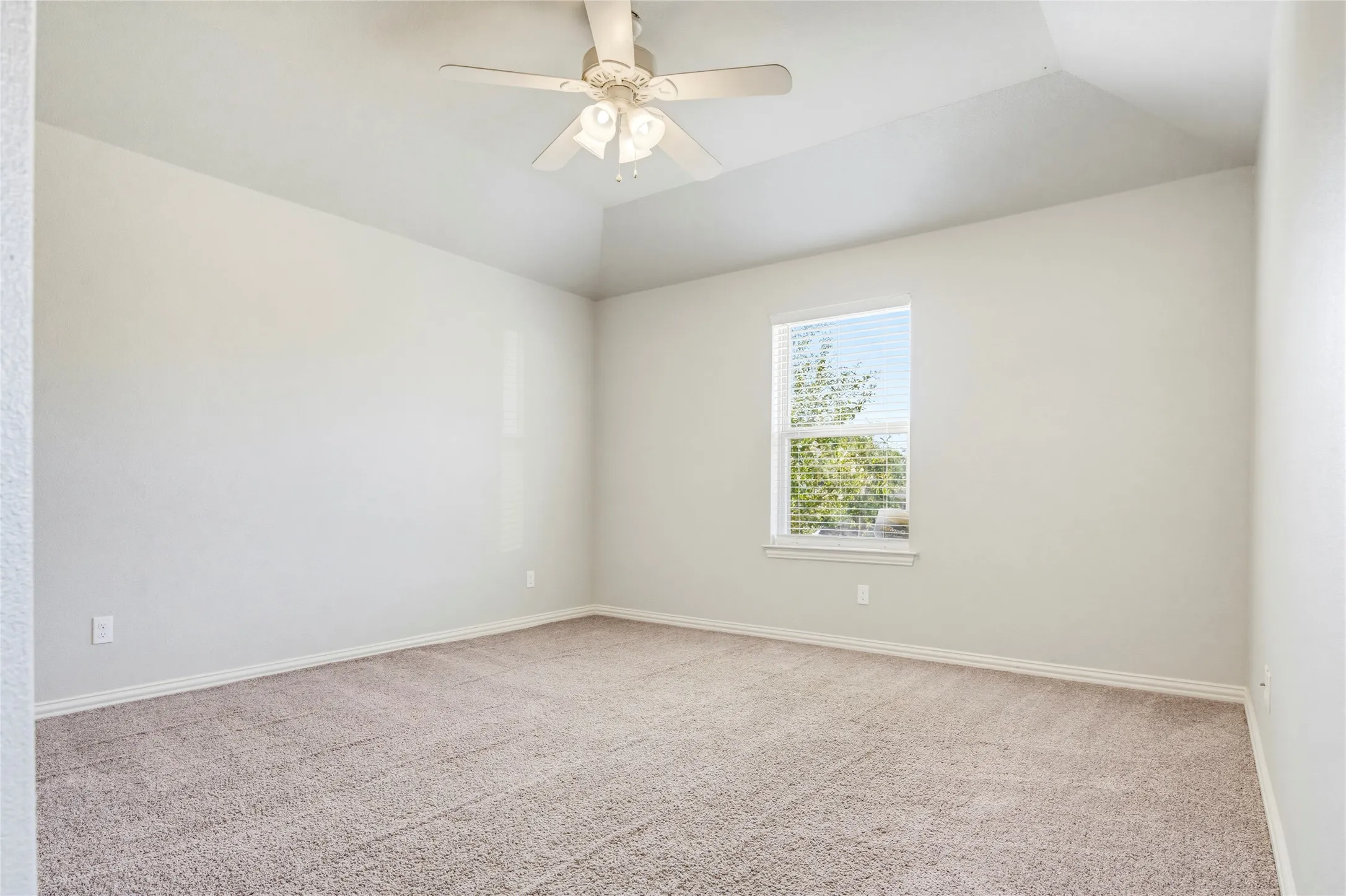 Vaulted ceiling with a ceiling fan, neutral wall tones, window with blinds, and carpet flooring