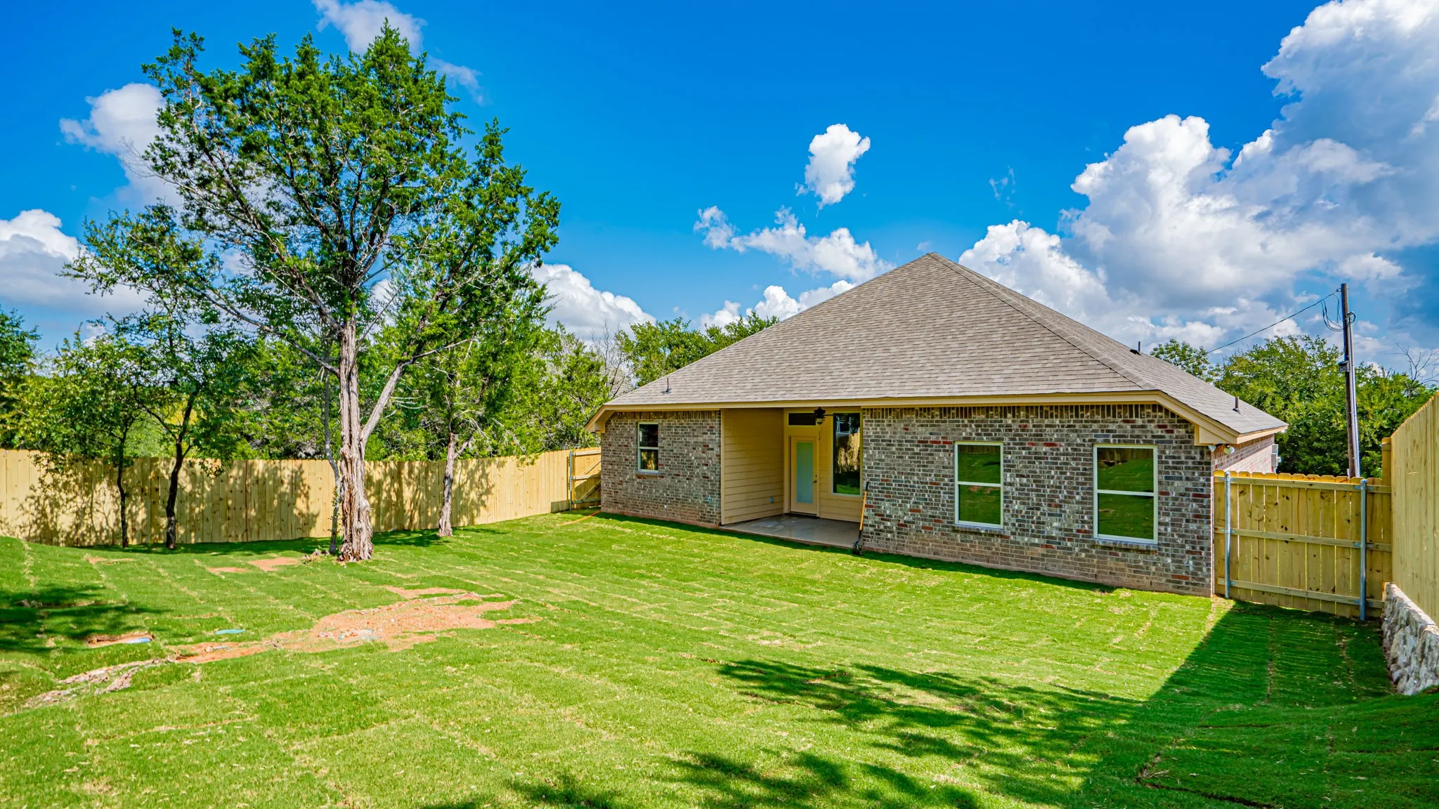 Covered patio at the back of home.  Fenced and sodded yard.
