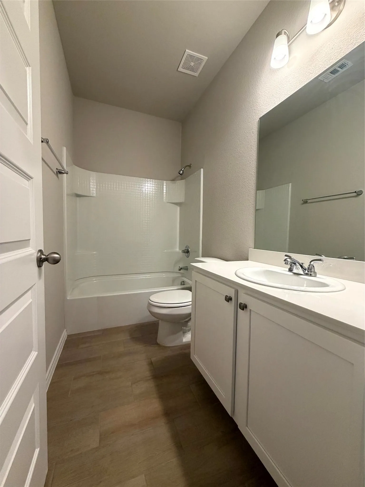 Bathroom featuring a single vanity with white cabinetry, integrated sink, and chrome faucet