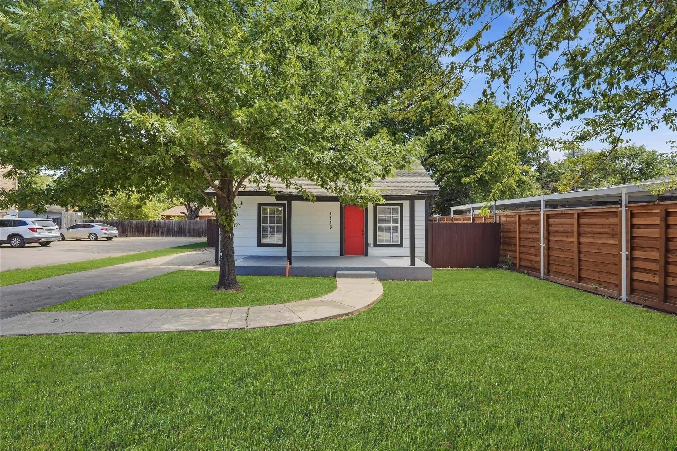 White siding exterior with a contrasting red entry door