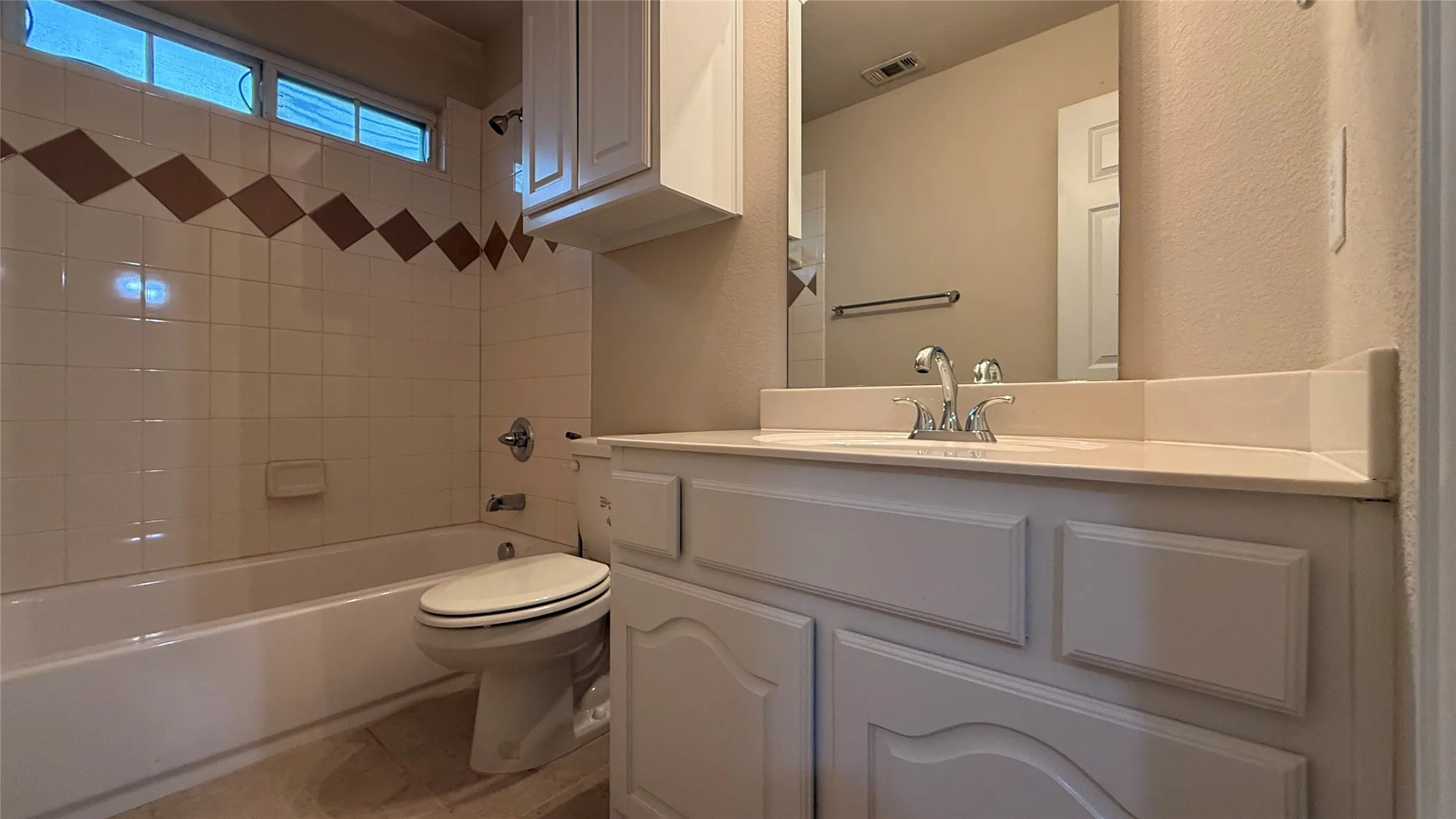 White vanity with integrated sink and chrome faucet, set against a full-width mirror