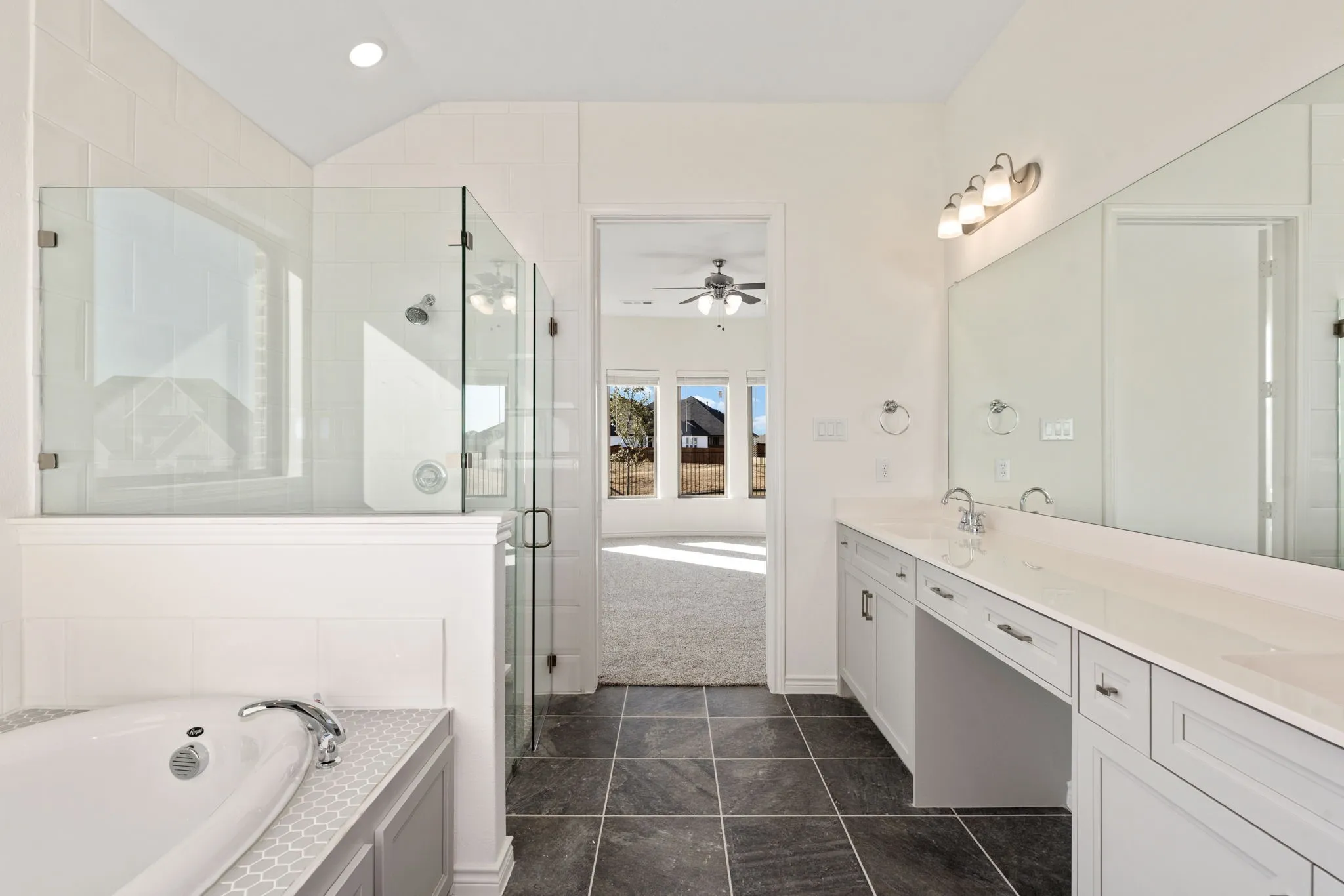 The primary bath offers separate vanities, a soaker tub, and a walk in shower.