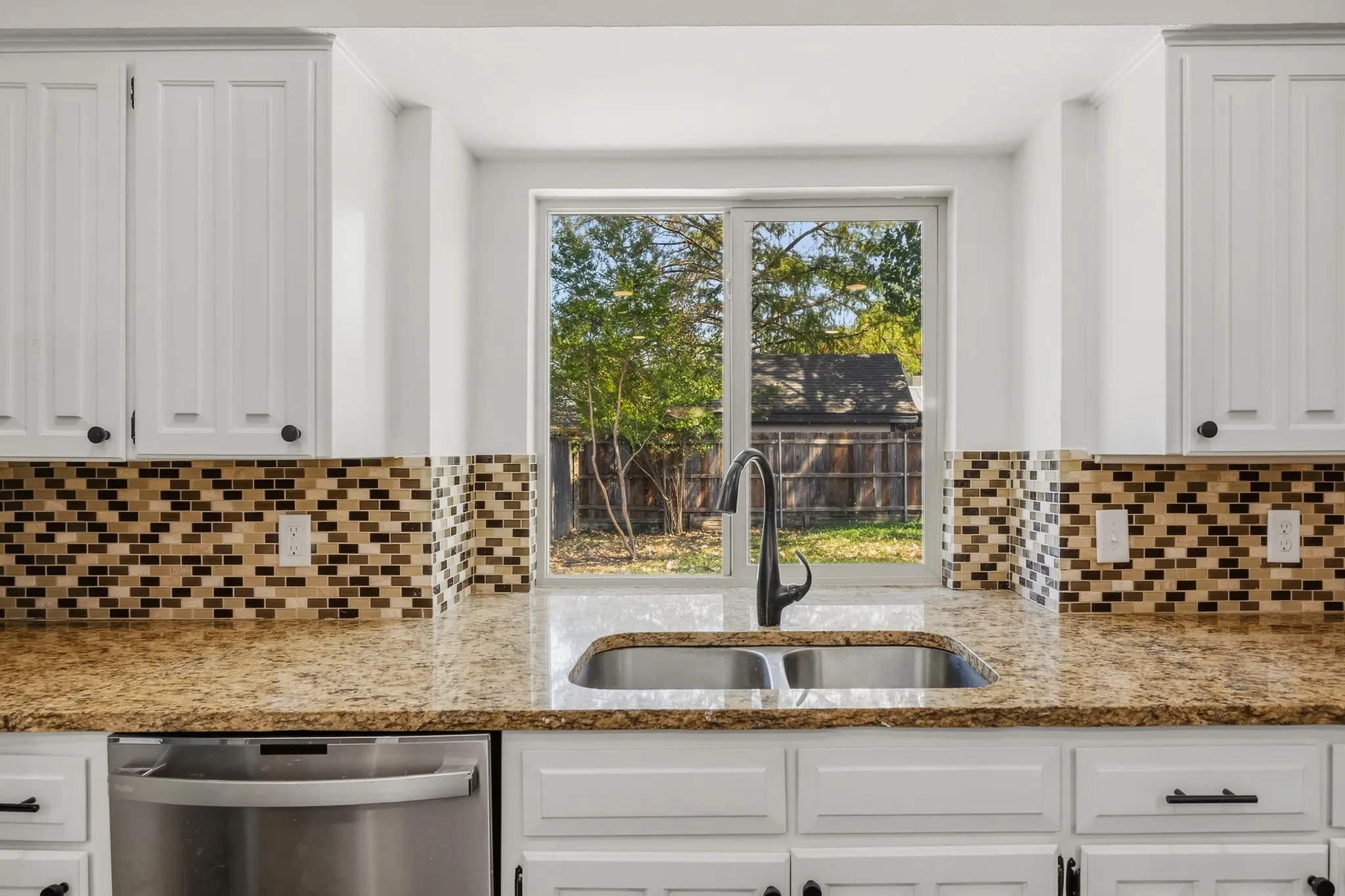 Window provides a view of the backyard.