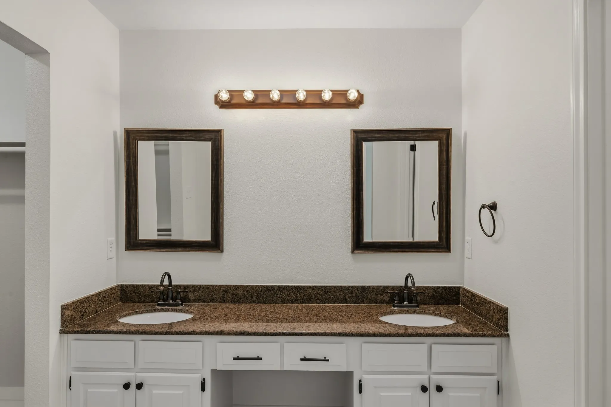 Primary bathroom with dual sinks and built in storage under the cabinet.