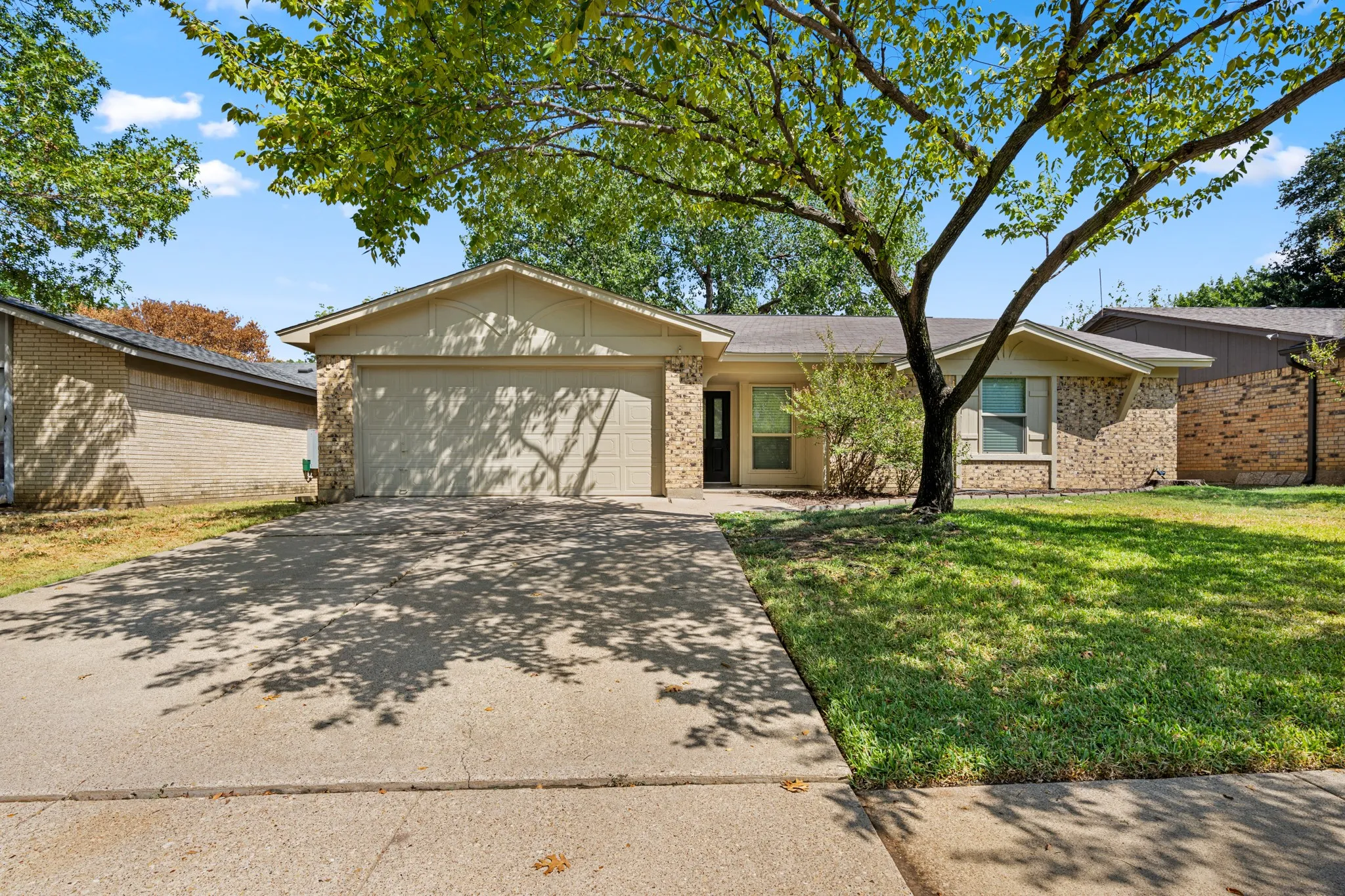 Charming single-story rental home featuring a welcoming brick exterior, mature shade tree, and spacious front lawn. The property offers an attached two-car garage, private driveway, and covered entry. Well-established landscaping and a quiet residential setting add to the home’s inviting curb appeal.