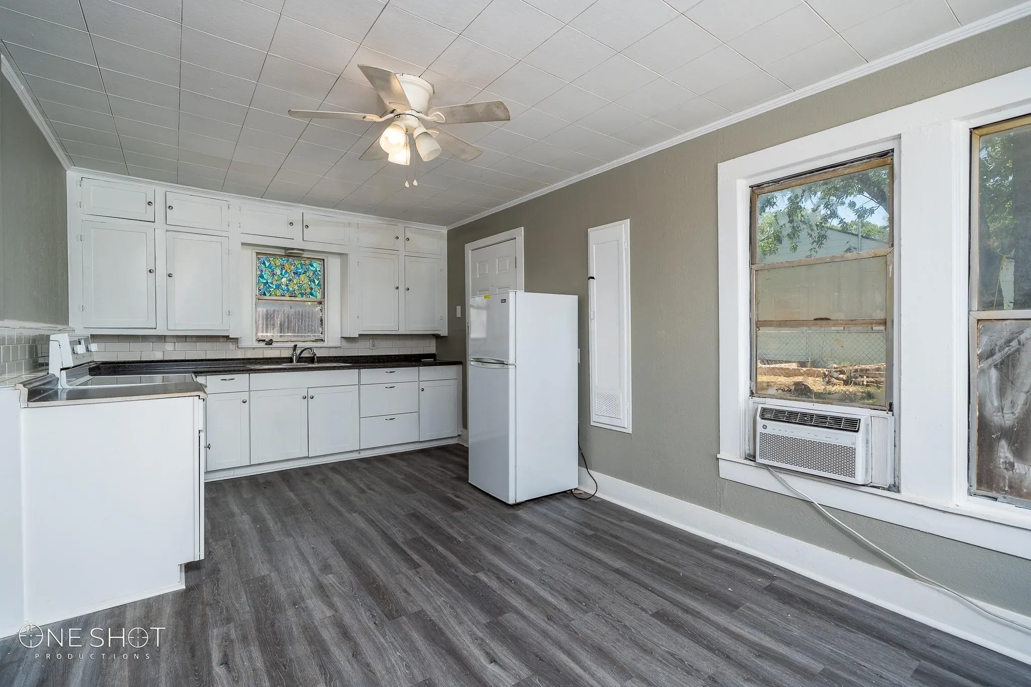 Kitchen featuring white cabinets, white refrigerator, dark hardwood / wood-style flooring, and plenty of natural light
