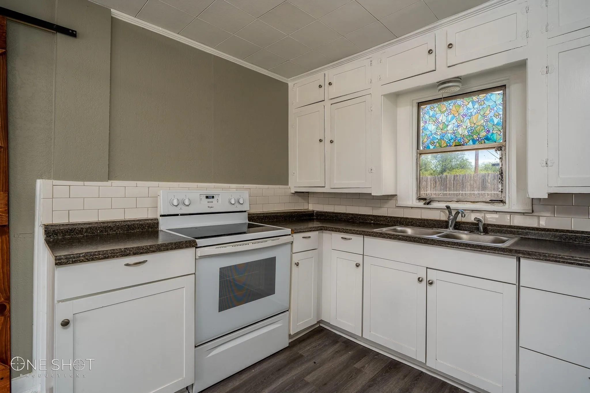 Kitchen with white cabinetry, electric stove, dark hardwood / wood-style flooring, sink, and backsplash