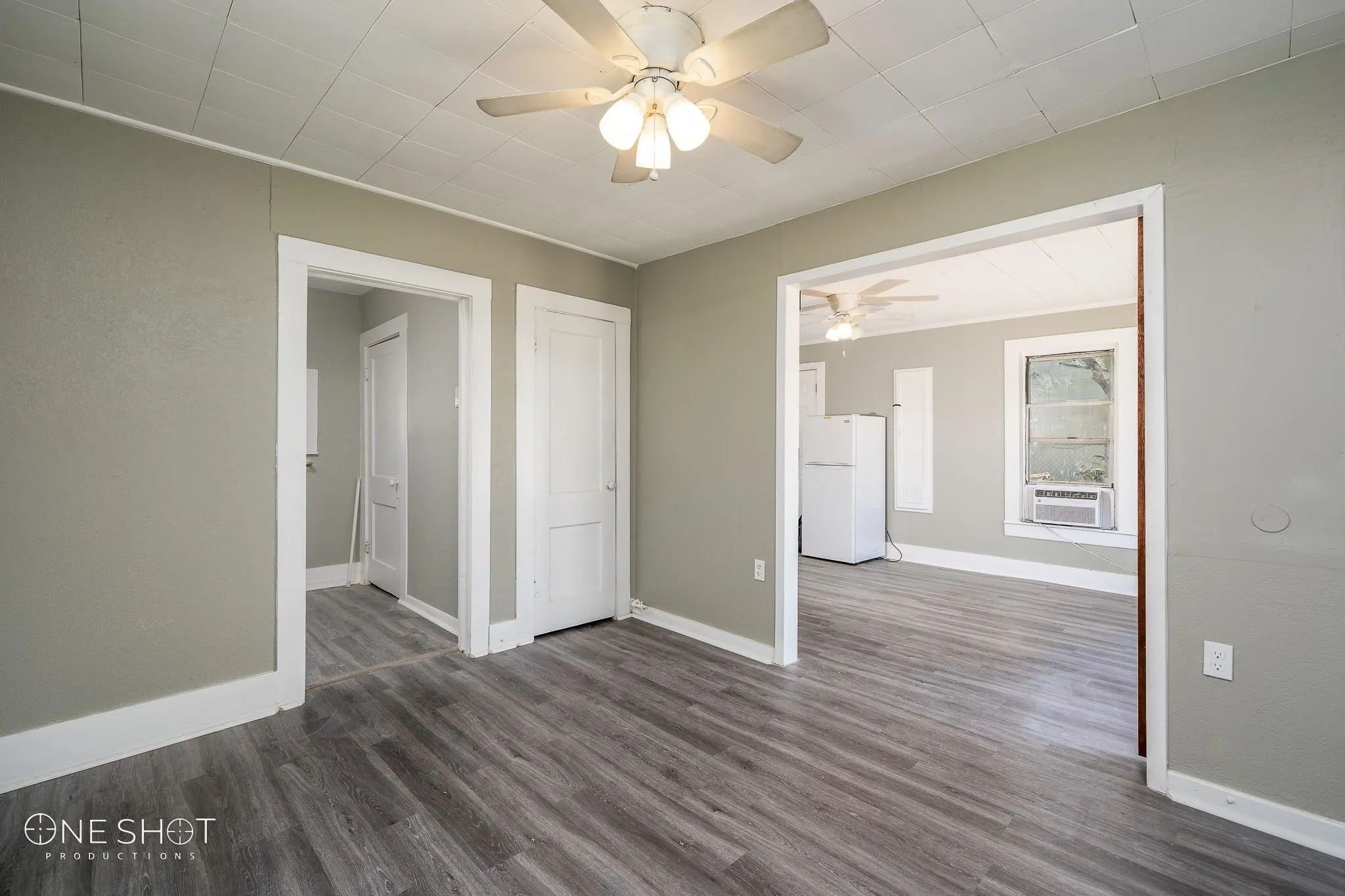 Spare room with cooling unit, dark wood-type flooring, and ceiling fan