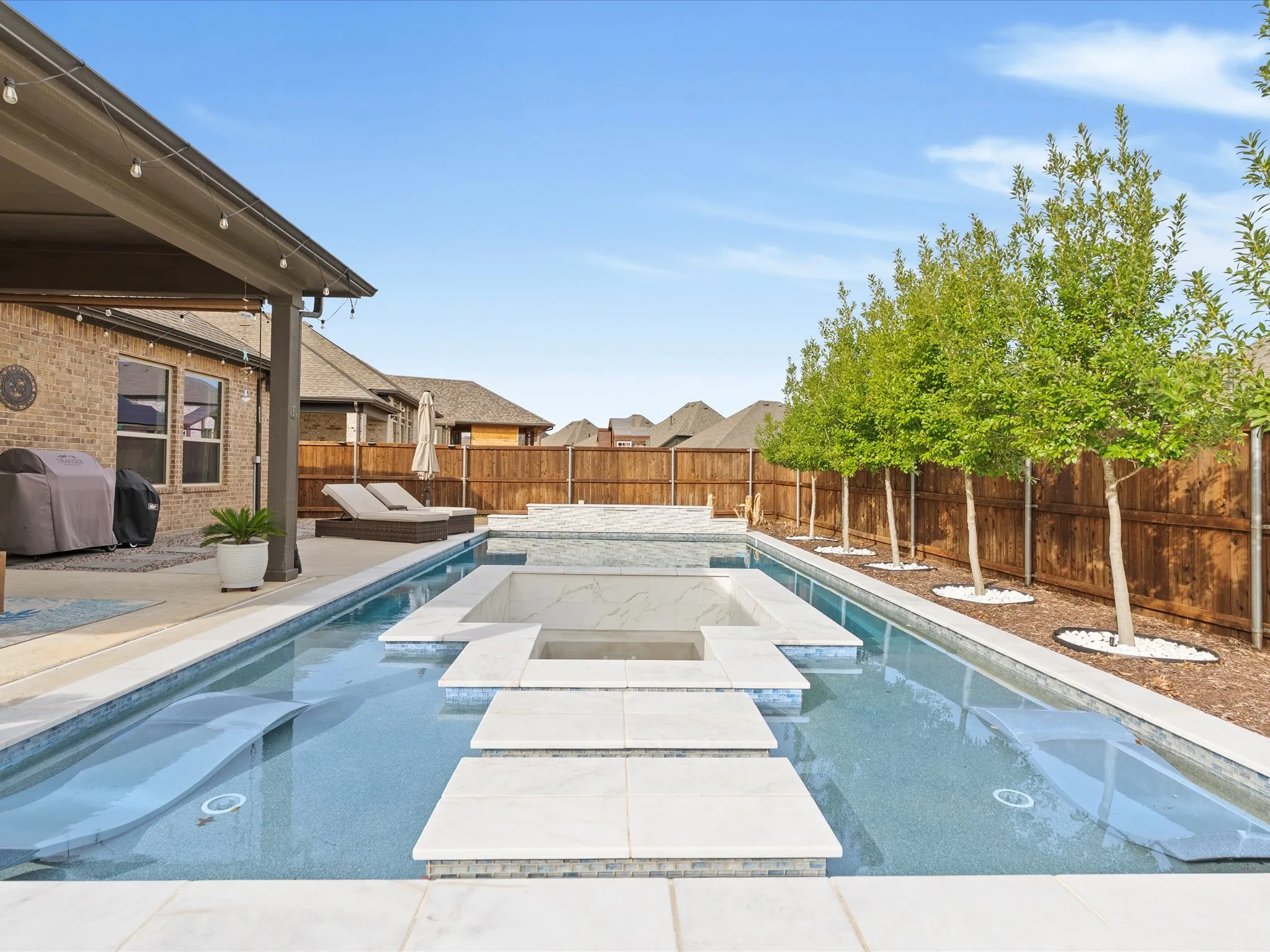 refreshing pool view featuring steps leading into a sunken lounge, creating a unique space to relax, socialize, and enjoy the water
