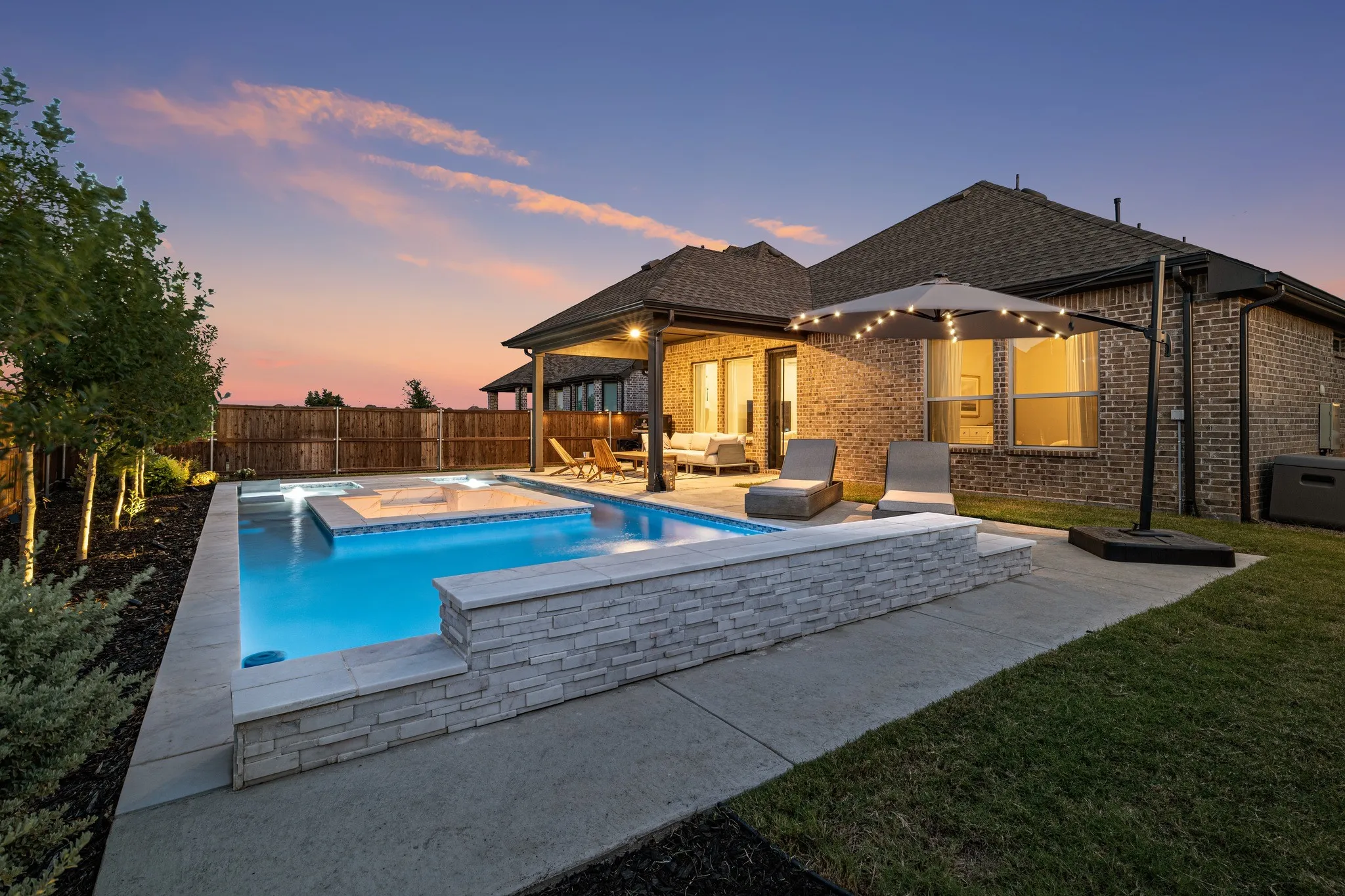 beautiful sunset view of the backyard pool and rear exterior of the home, creating a warm and inviting setting for relaxing and enjoying the evening outdoors