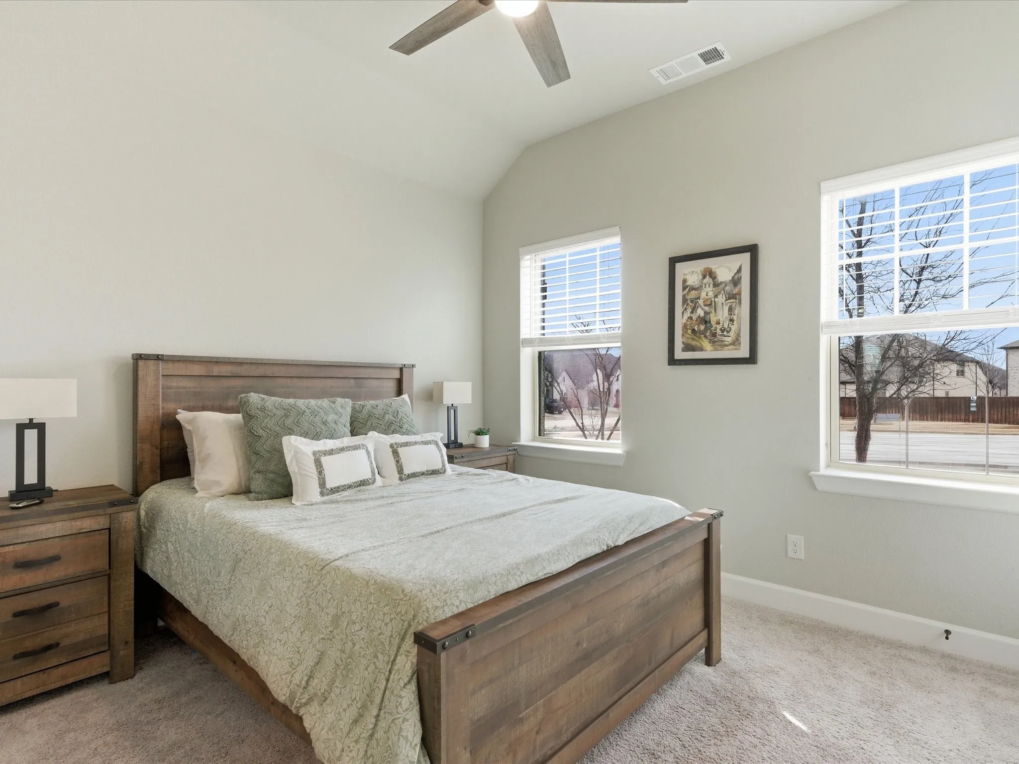 cozy bedroom featuring two windows that bring in natural light and offer a pleasant outdoor view, creating a bright and relaxing retreat