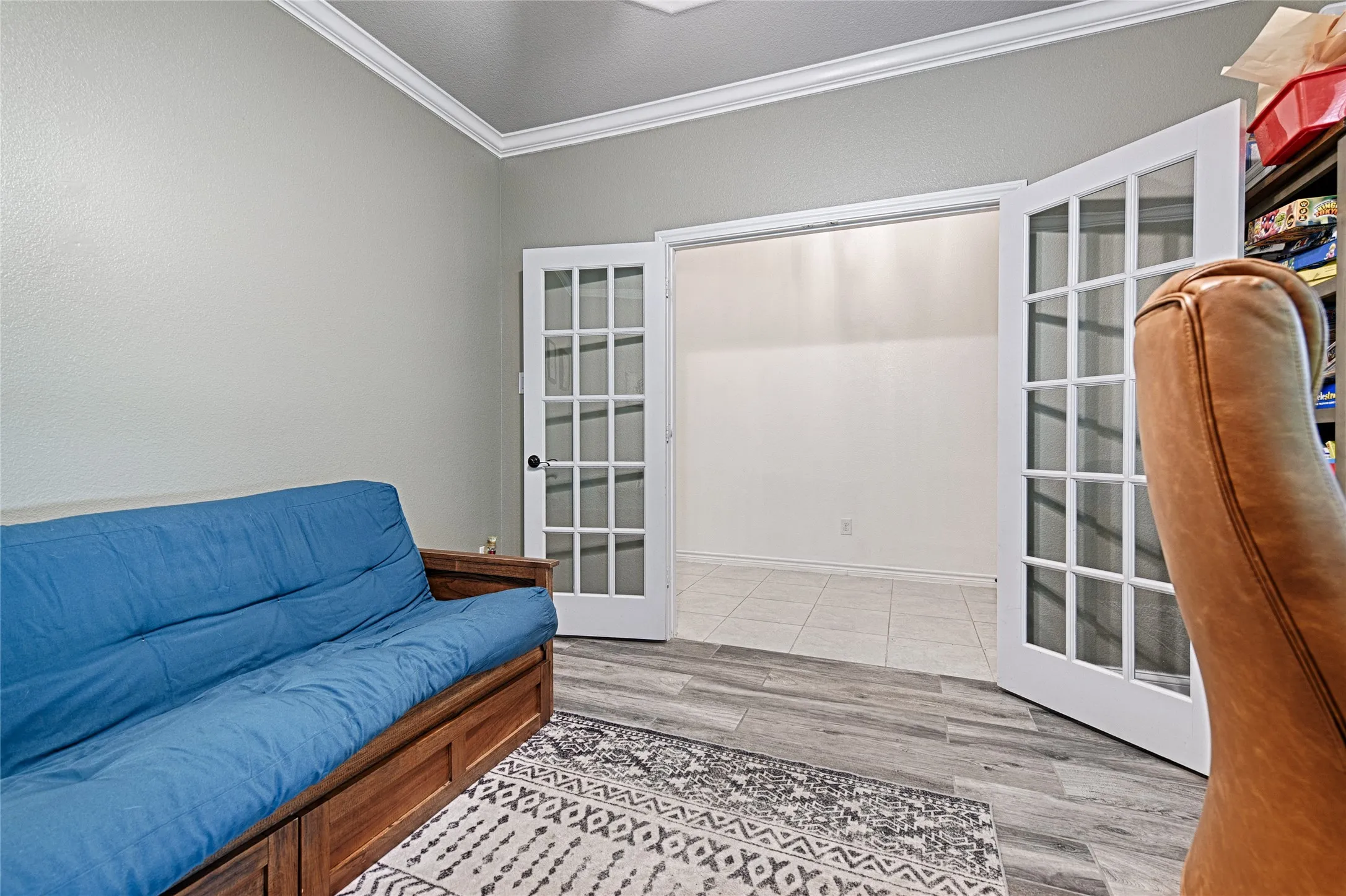 Living room with hardwood / wood-style flooring, ornamental molding, and french doors