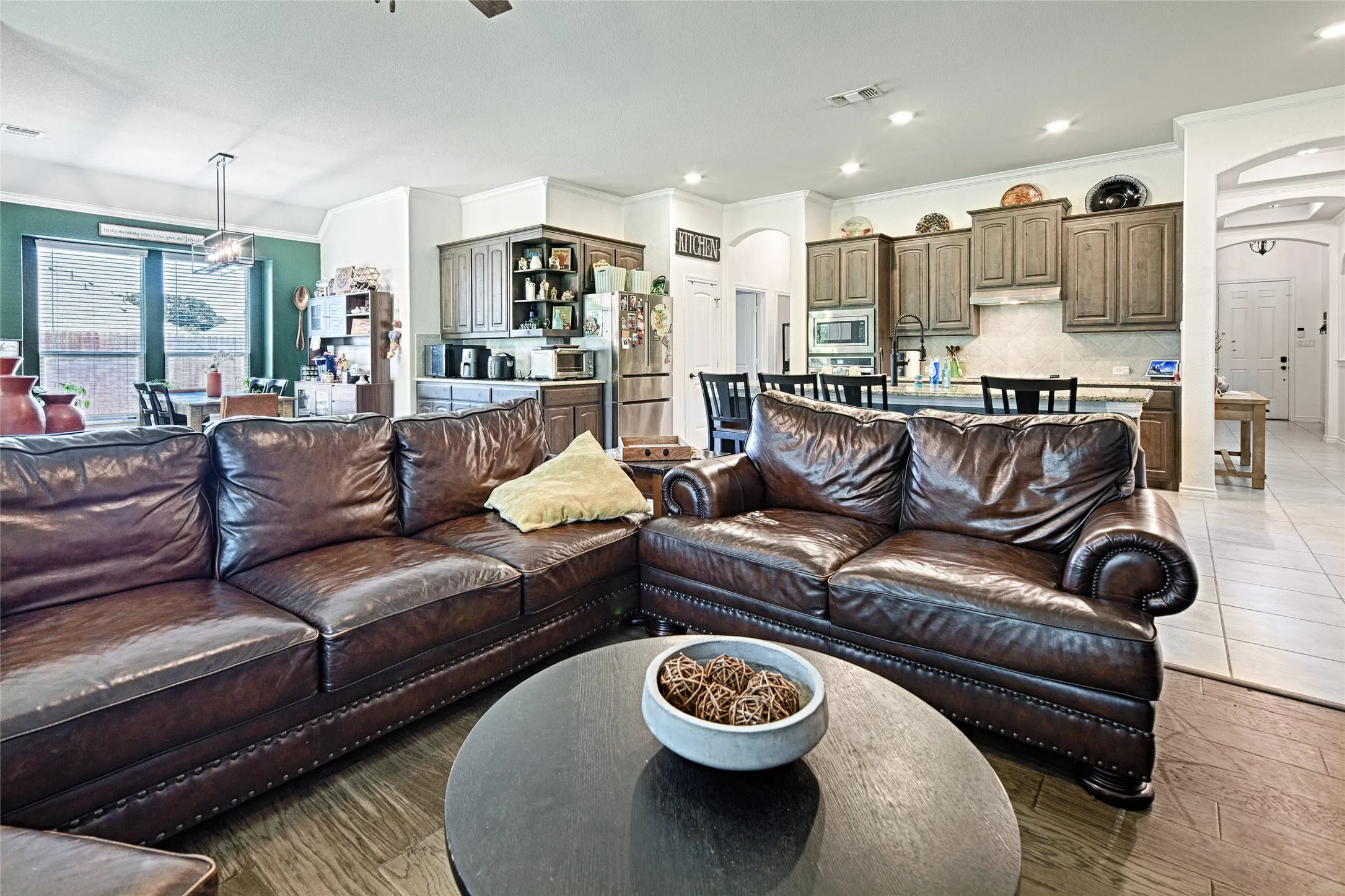 Tiled living room featuring ornamental molding and ceiling fan