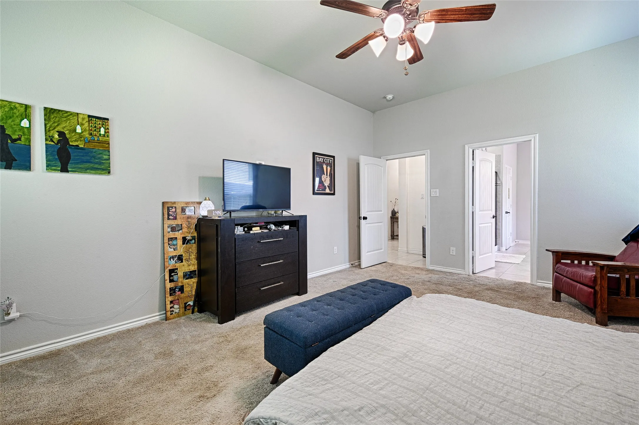Bedroom featuring ensuite bathroom, ceiling fan, and light colored carpet