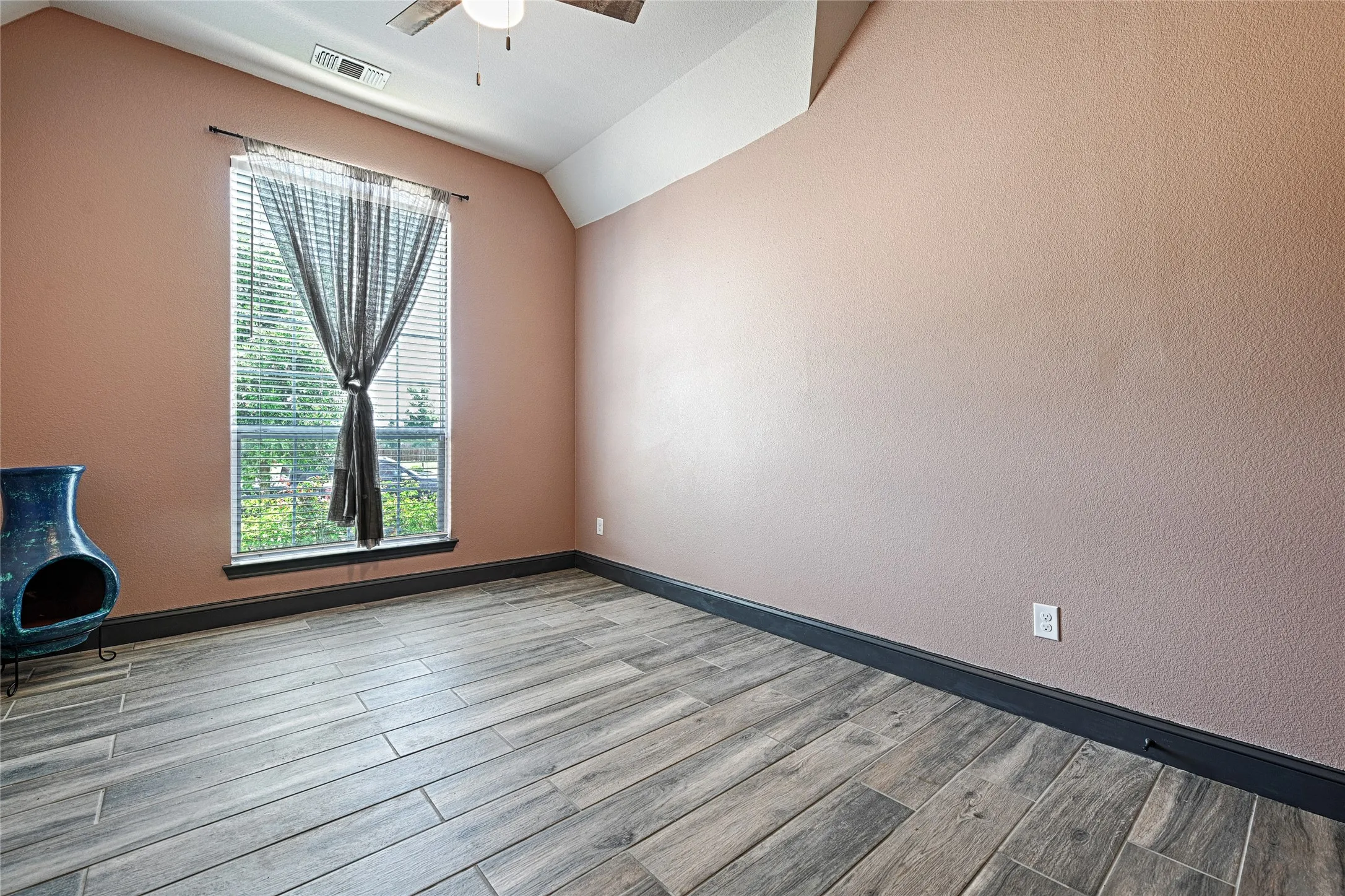 Unfurnished room with ceiling fan, hardwood / wood-style flooring, and lofted ceiling