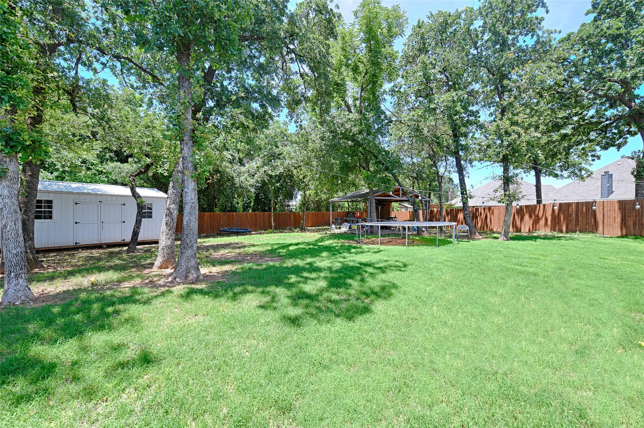 View of yard featuring an outdoor structure and a trampoline