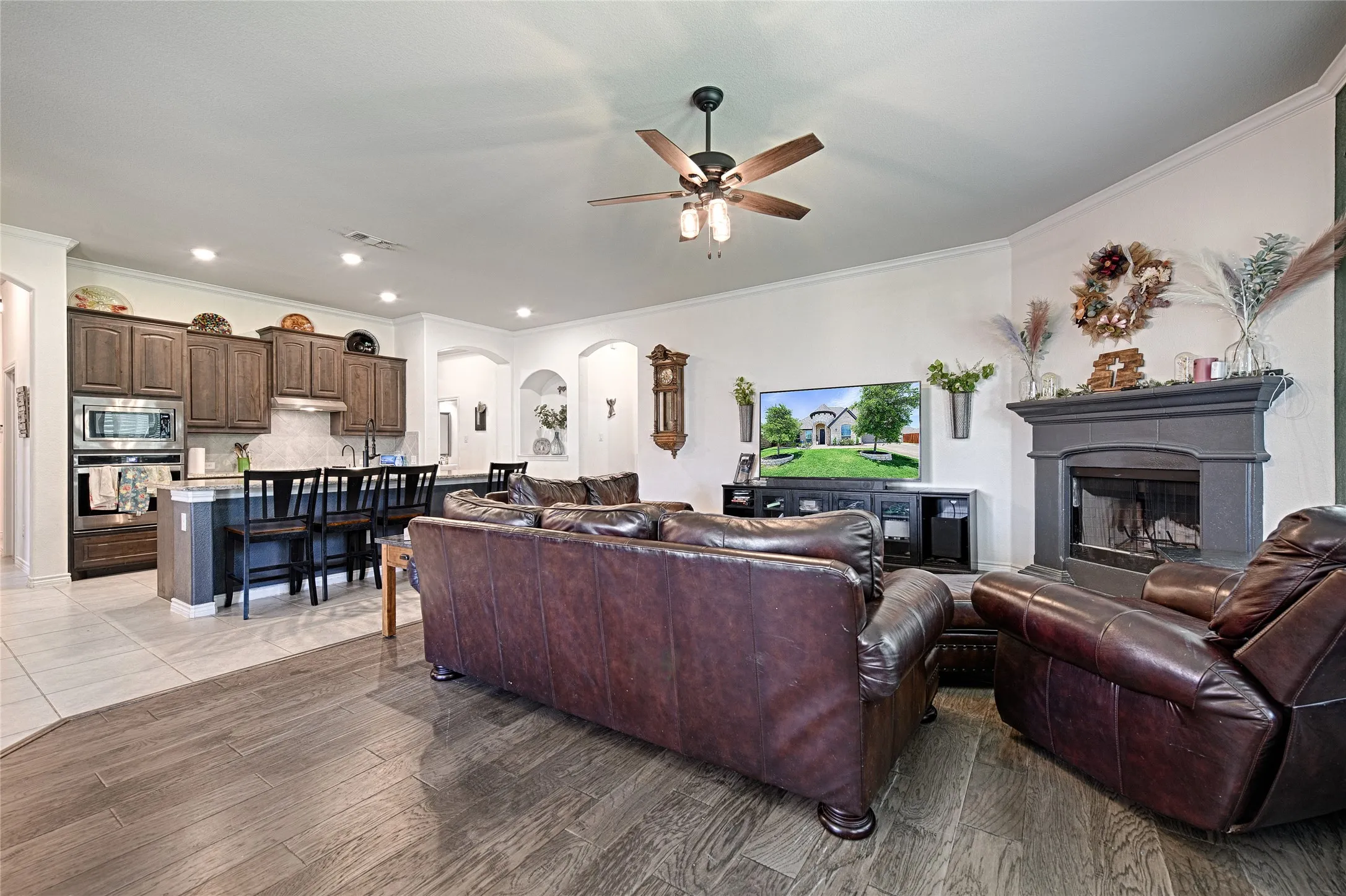 Tiled living room featuring ornamental molding and ceiling fan