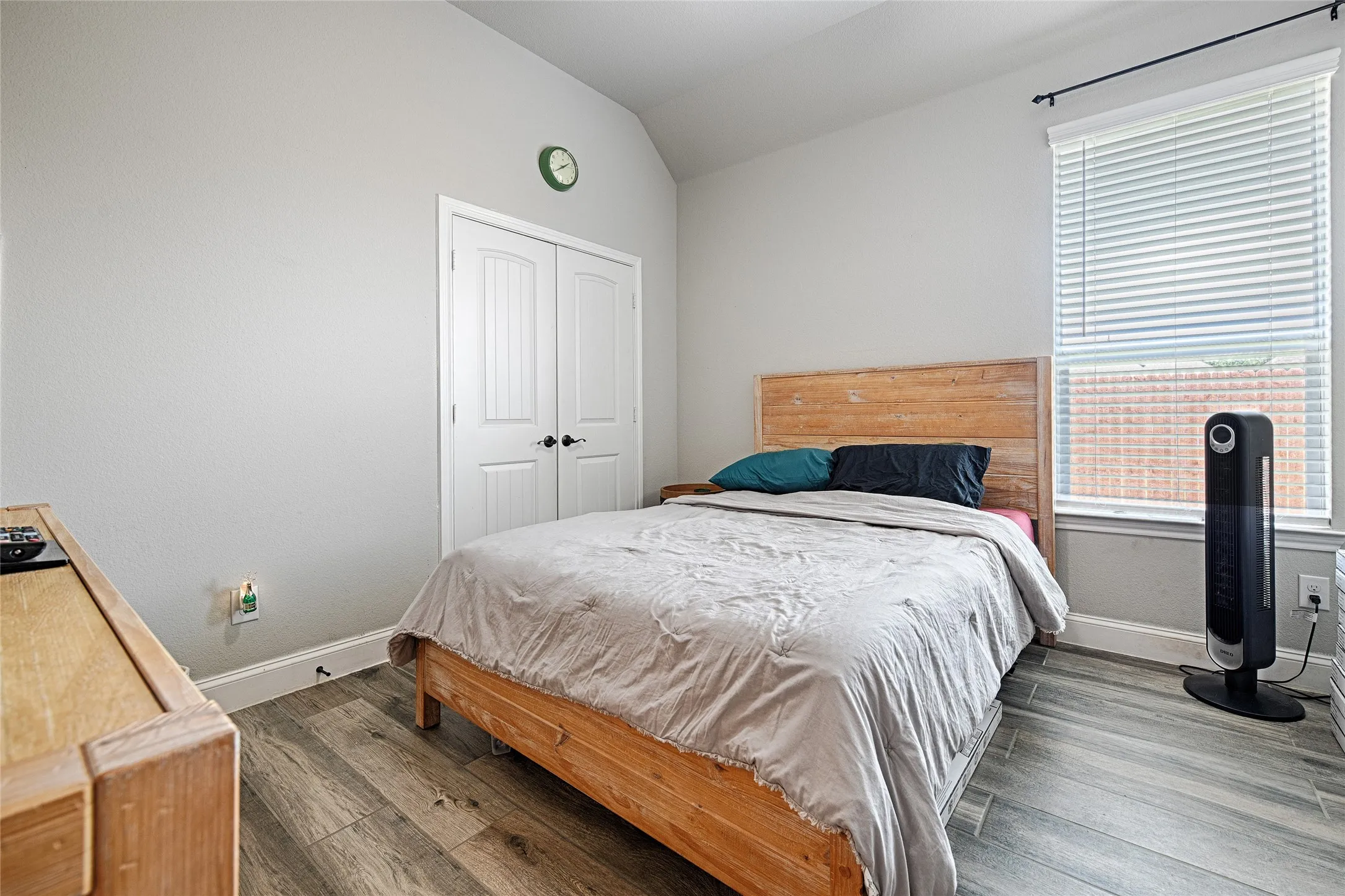 Bedroom with a closet, vaulted ceiling, and hardwood / wood-style floors