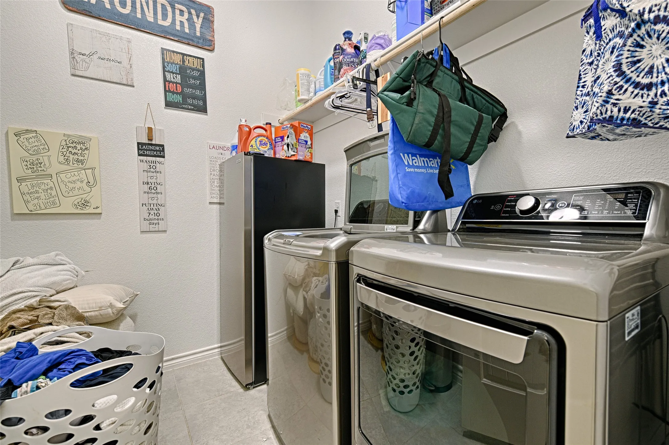 Laundry room featuring washing machine and dryer and light tile floors