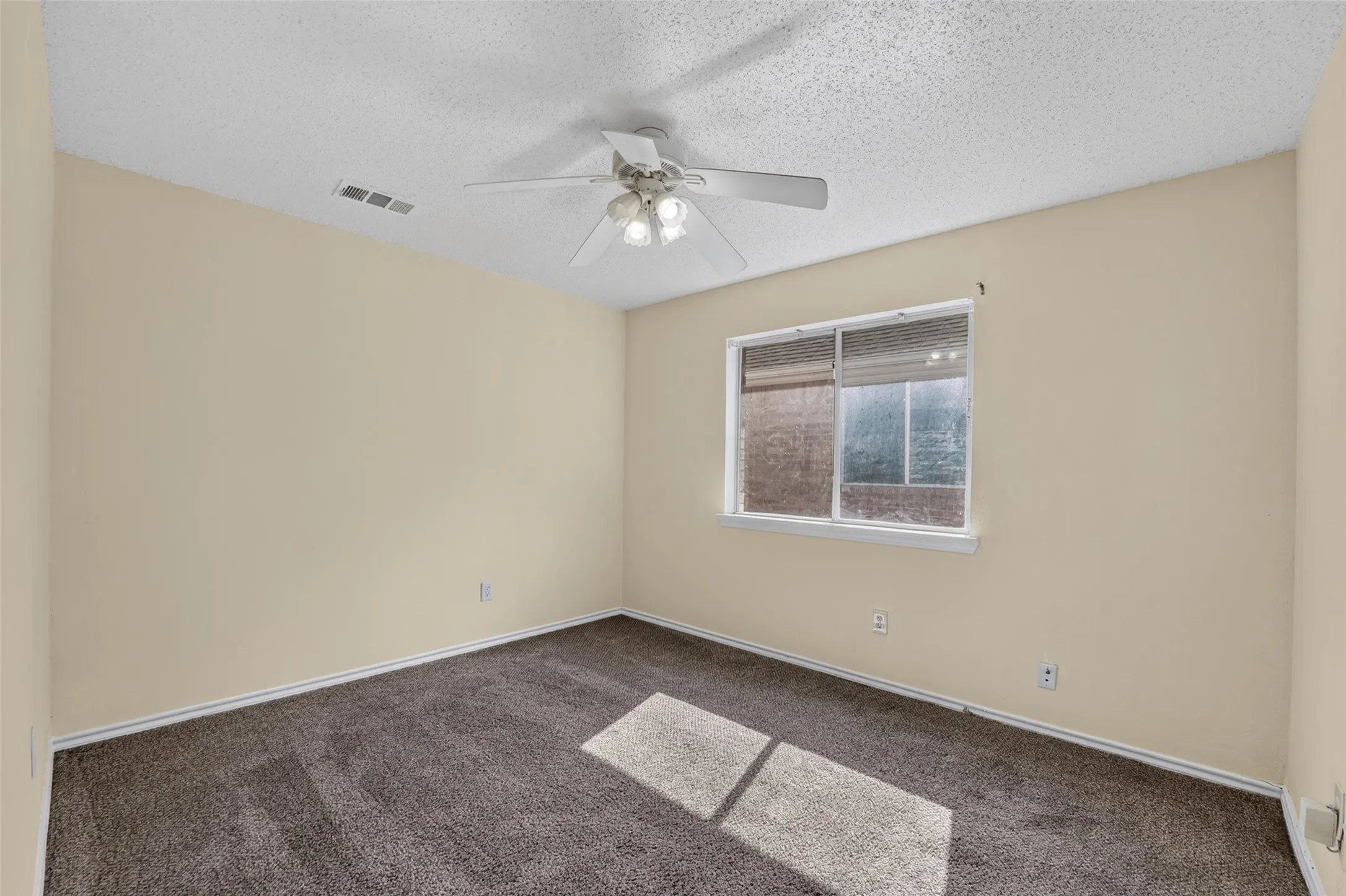 Neutral-toned walls complement the dark carpeting