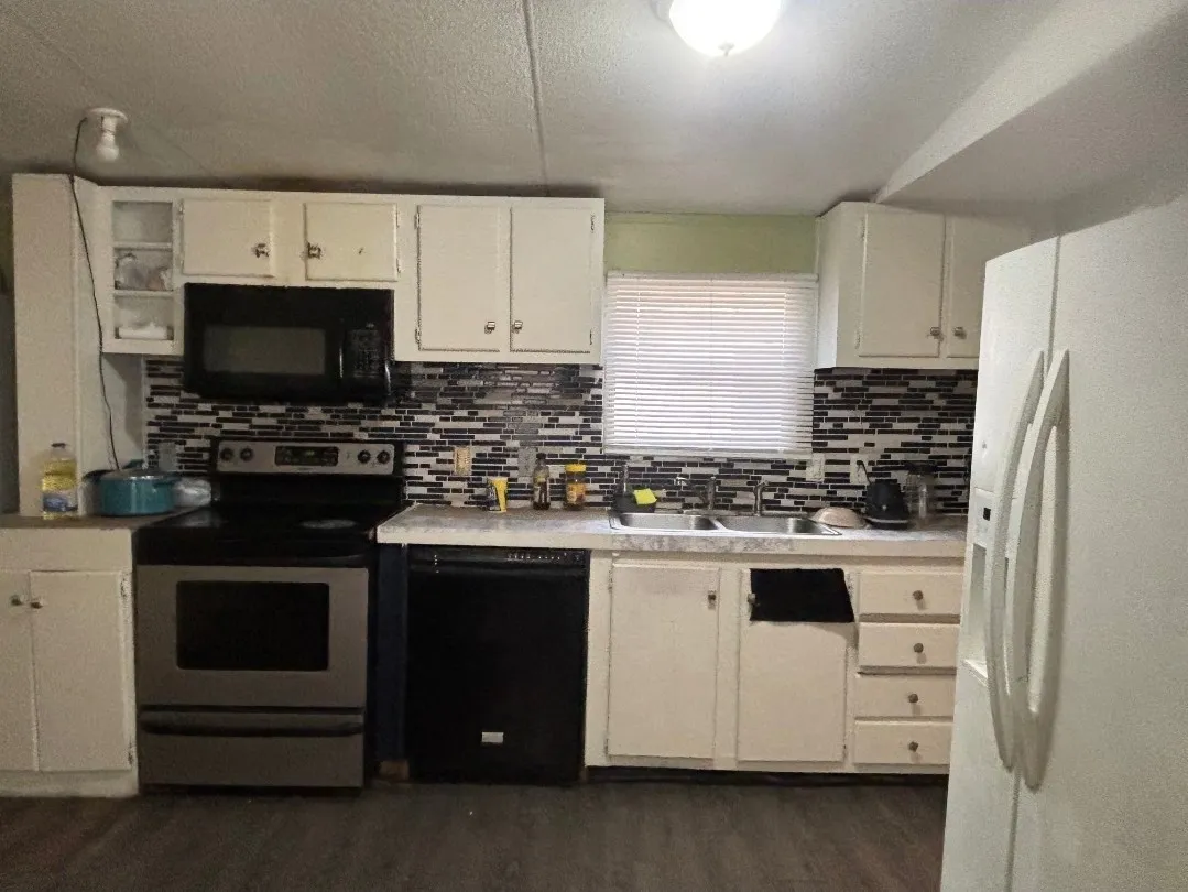 Kitchen featuring a stainless steel range, built-in microwave, white cabinetry, dark wood-finish flooring, and a tile backsplash