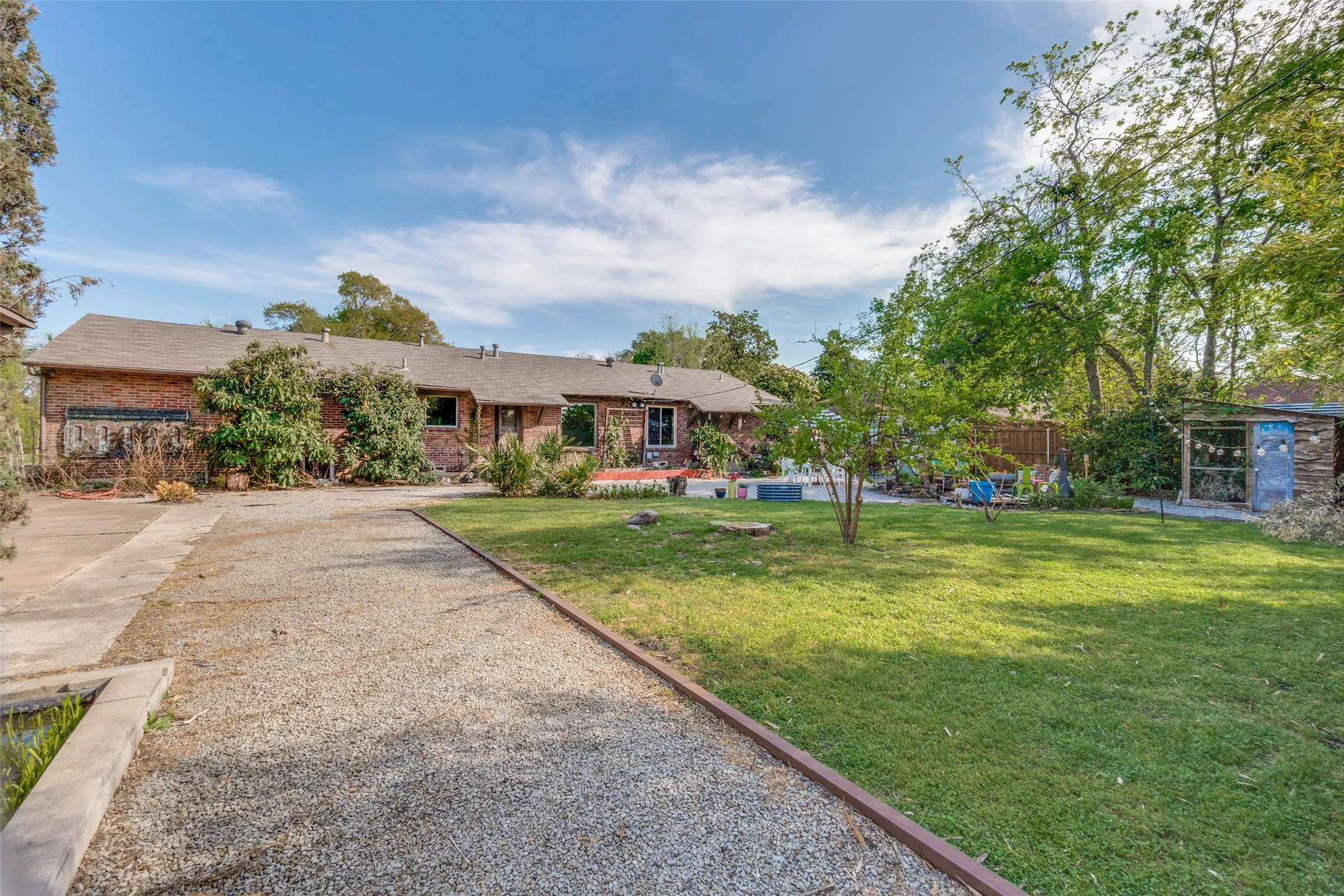 View of front of property with brick siding, a front yard, and fence