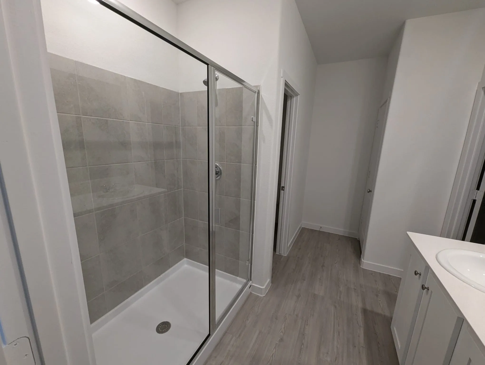 Bathroom featuring vanity, wood-type flooring, and a shower with door