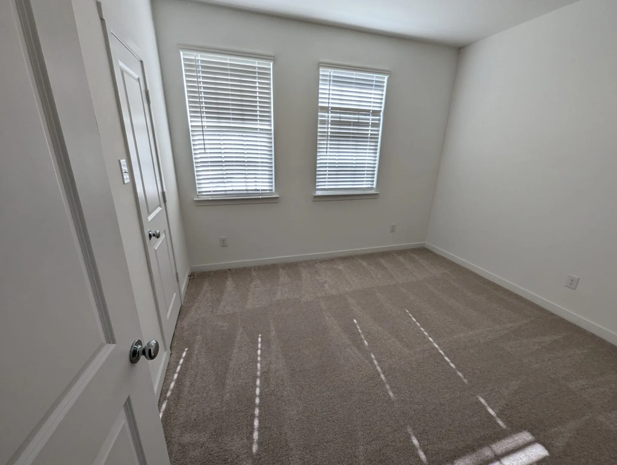 Unfurnished room with dark colored carpet and a healthy amount of sunlight