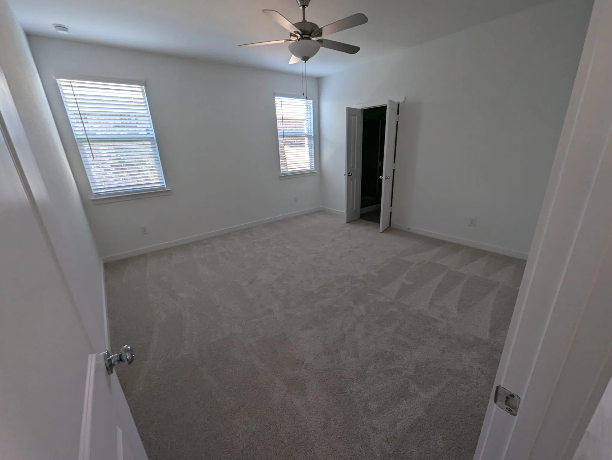 Unfurnished bedroom with ceiling fan and carpet