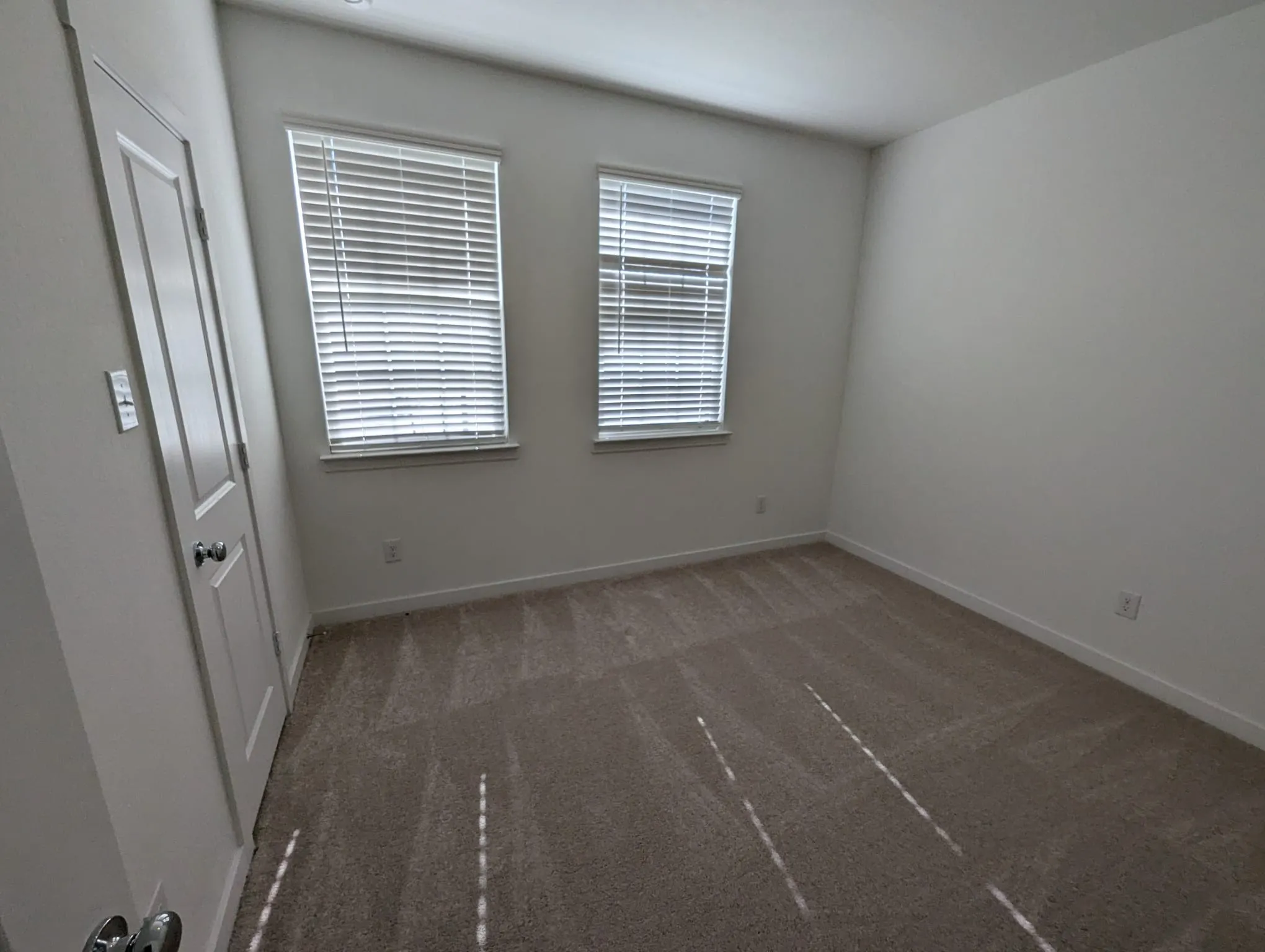 Empty room with dark carpet and plenty of natural light