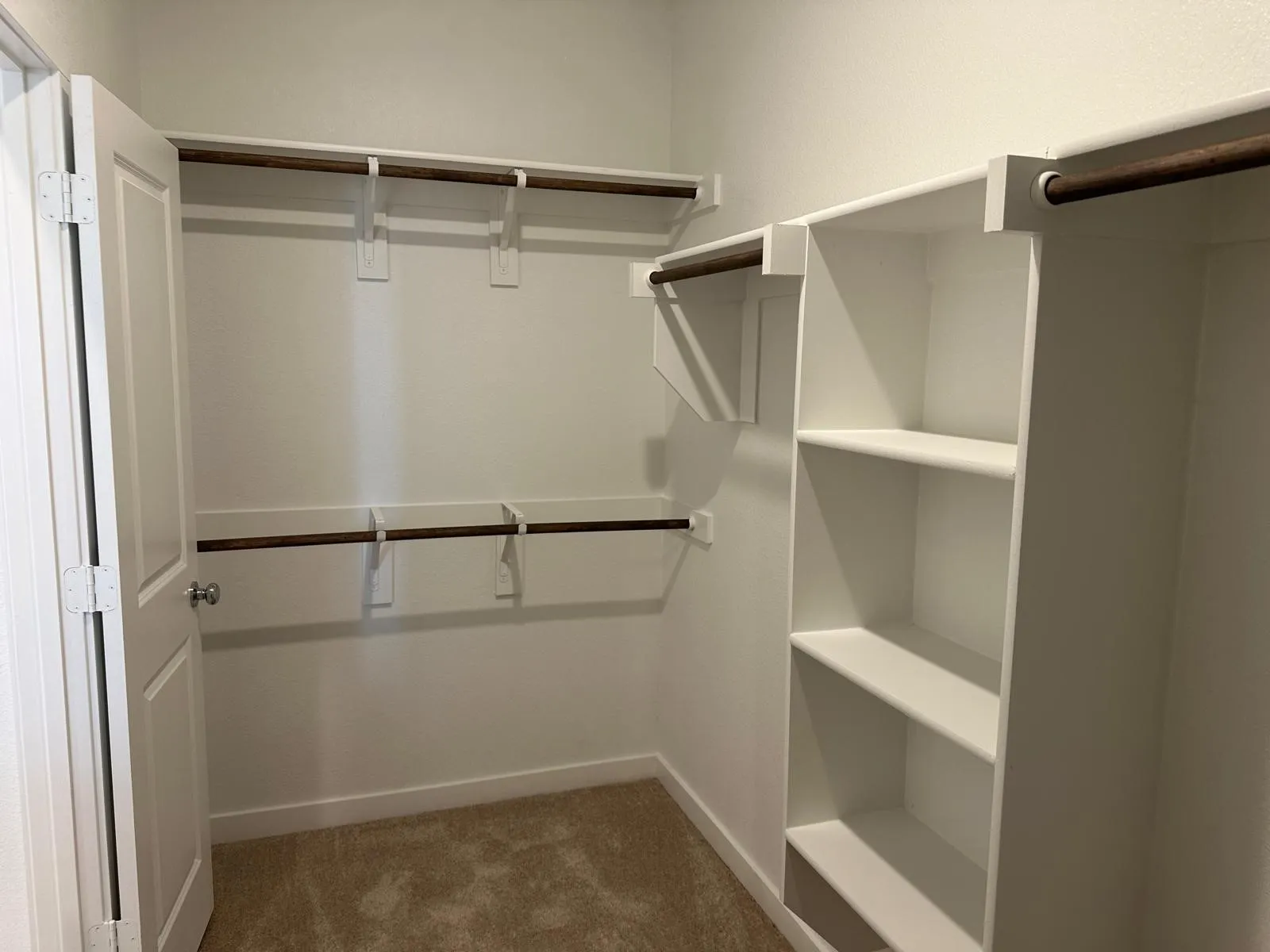 Walk in closet featuring dark carpet