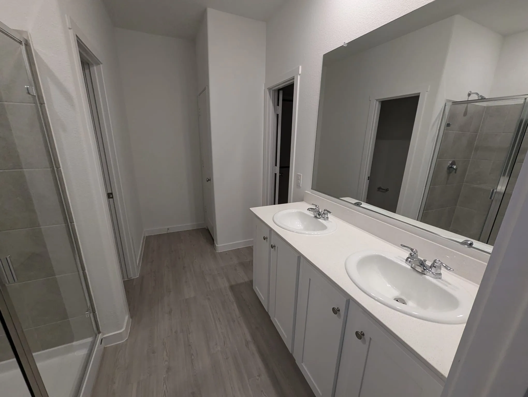 Bathroom with hardwood / wood-style flooring, vanity, and a shower with shower door