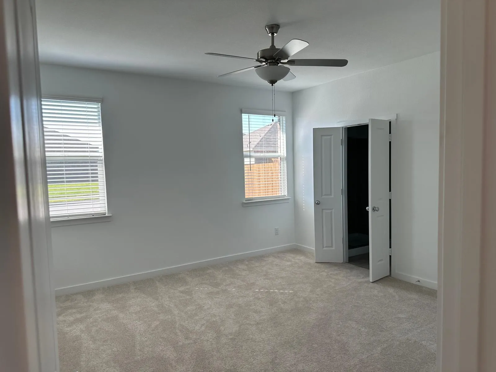 Unfurnished bedroom with ceiling fan and light colored carpet