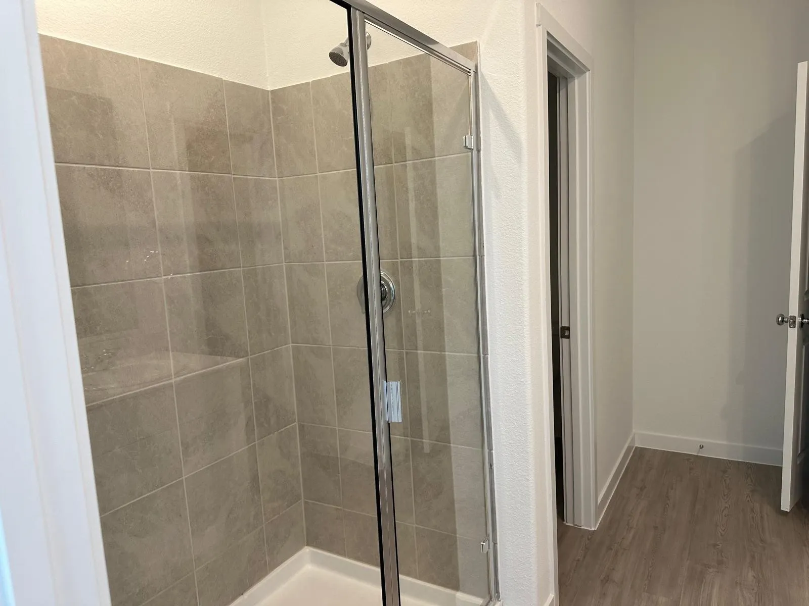 Bathroom with a shower with shower door and hardwood / wood-style flooring