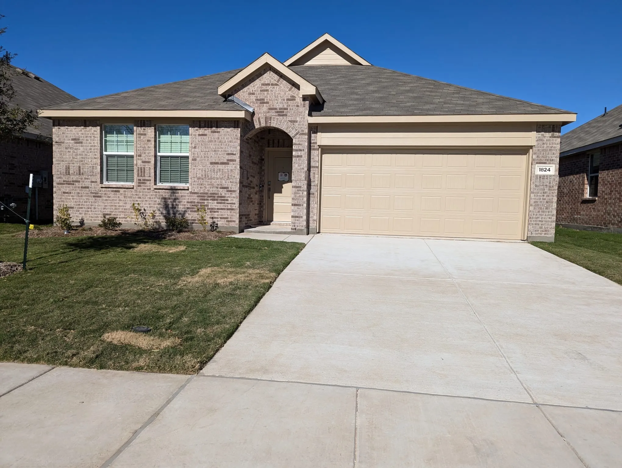 View of front of property featuring a garage and a front lawn