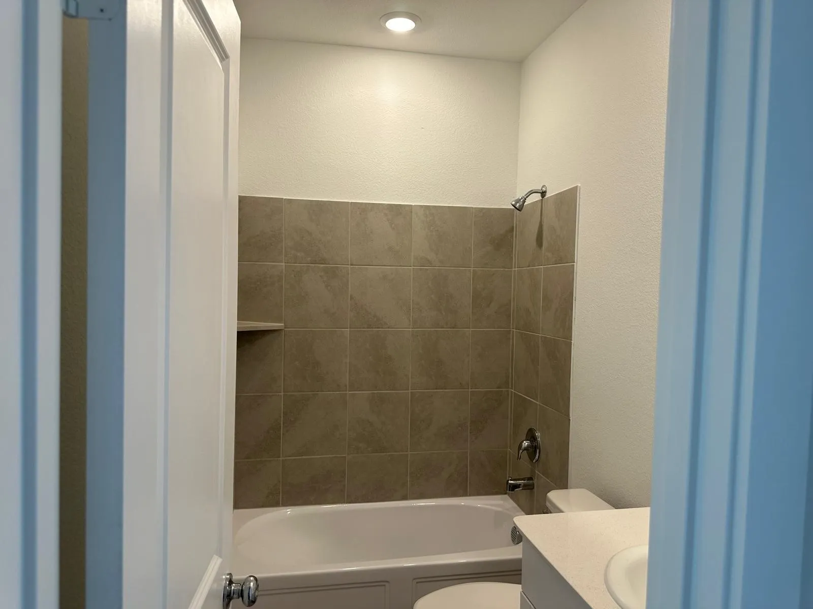 Full bathroom with vanity, toilet, and tiled shower / bath combo
