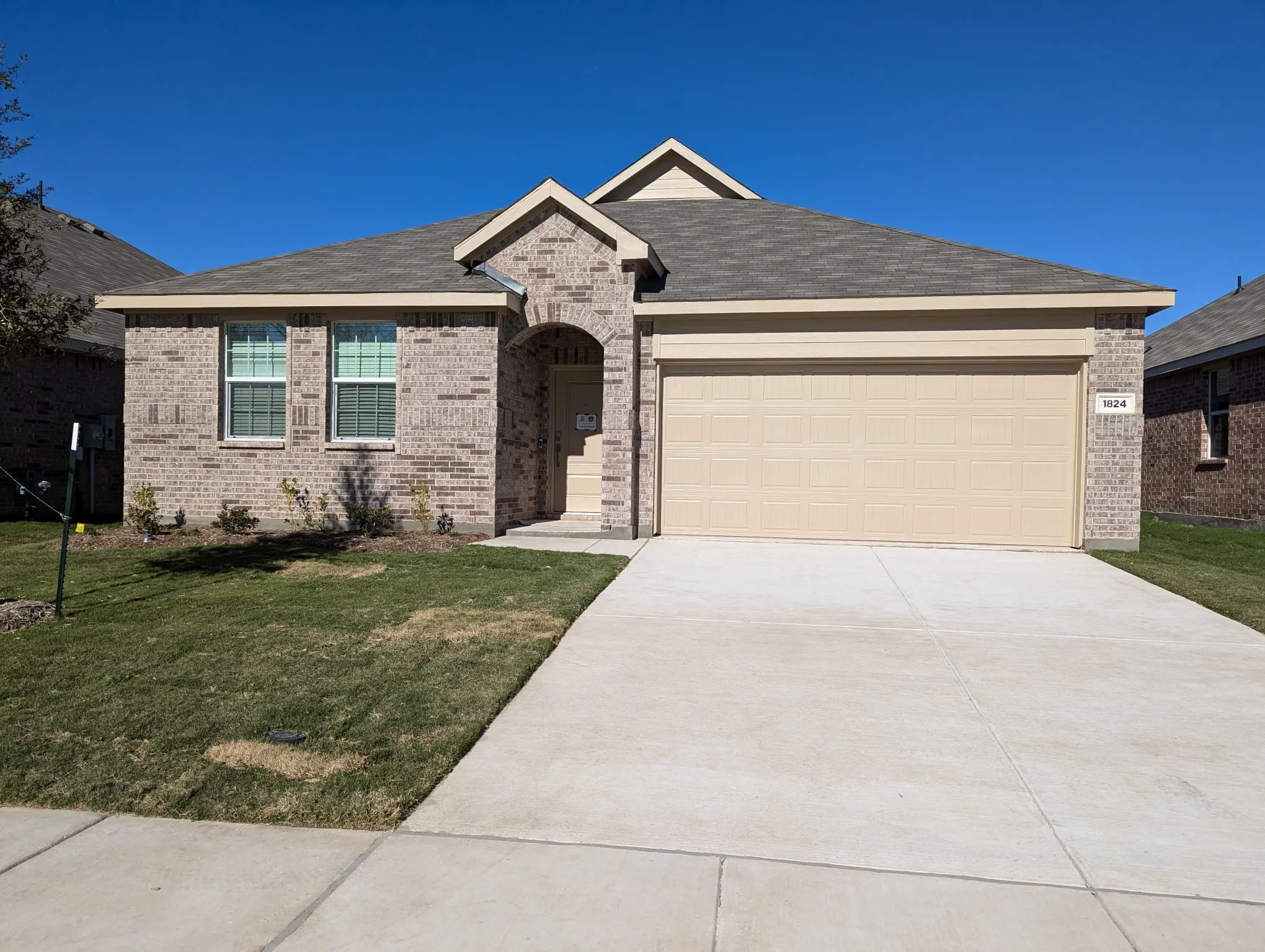 Ranch-style house featuring a front yard and a garage