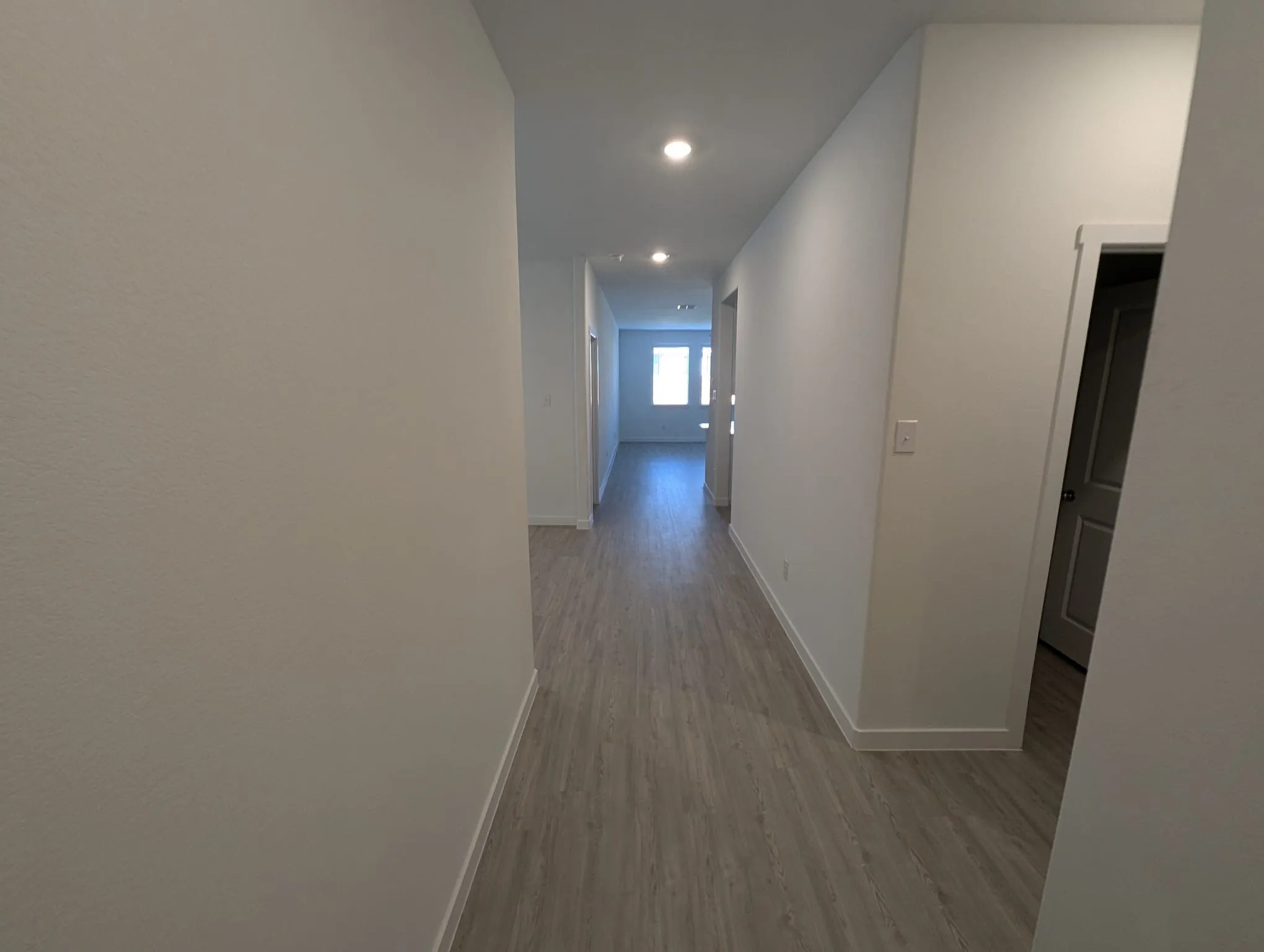 Corridor with light hardwood / wood-style flooring