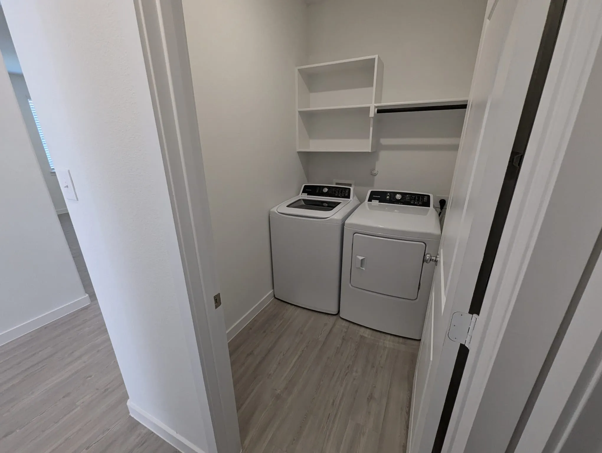 Laundry room with light wood-type flooring and washing machine and clothes dryer