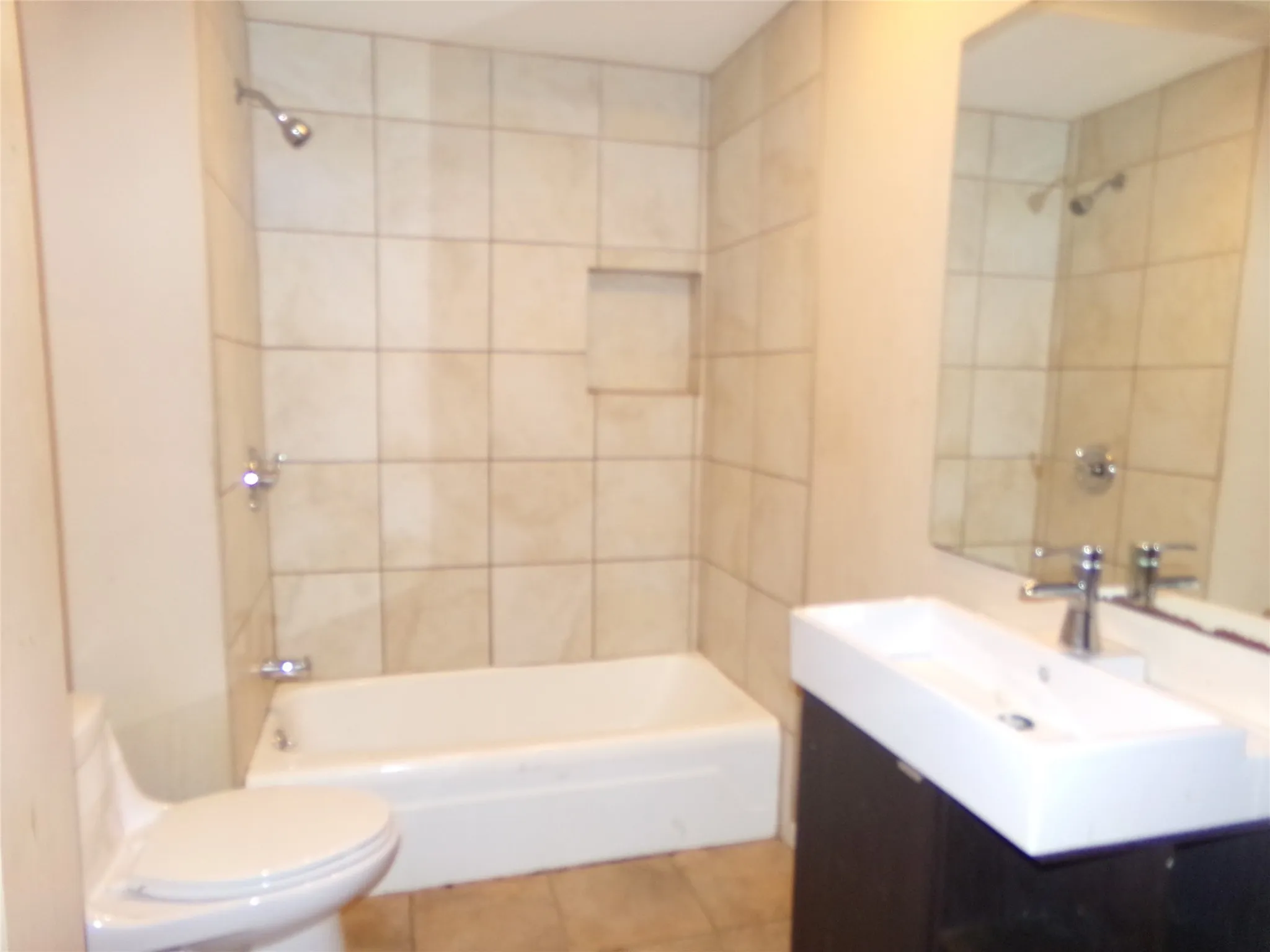 Wall-mounted vanity with a rectangular basin sink, chrome faucet, and integrated mirror