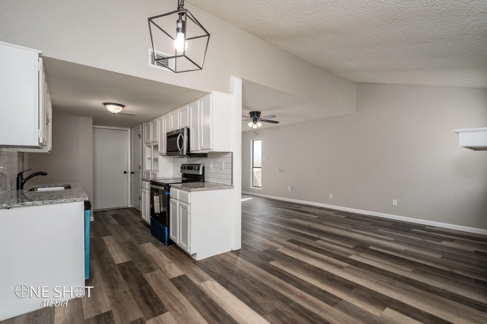 Kitchen featuring white cabinets, dark hardwood / wood-style floors, electric range oven, decorative backsplash, and sink