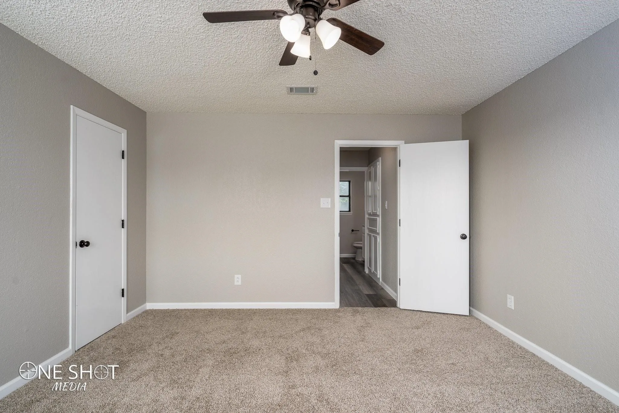 Unfurnished bedroom with a textured ceiling, ceiling fan, and carpet flooring