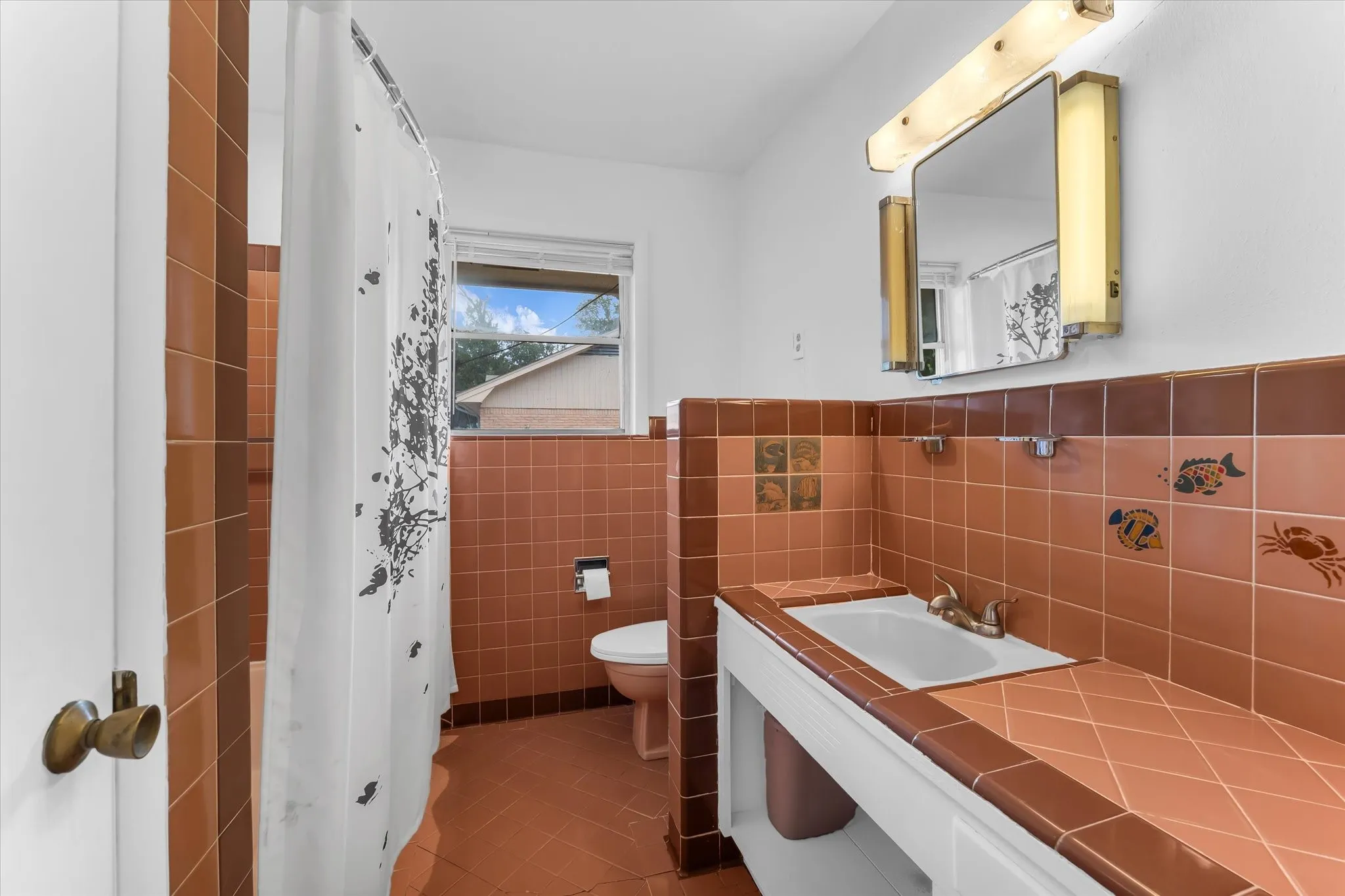 The hall bath features a tub and shower combo and original tile.