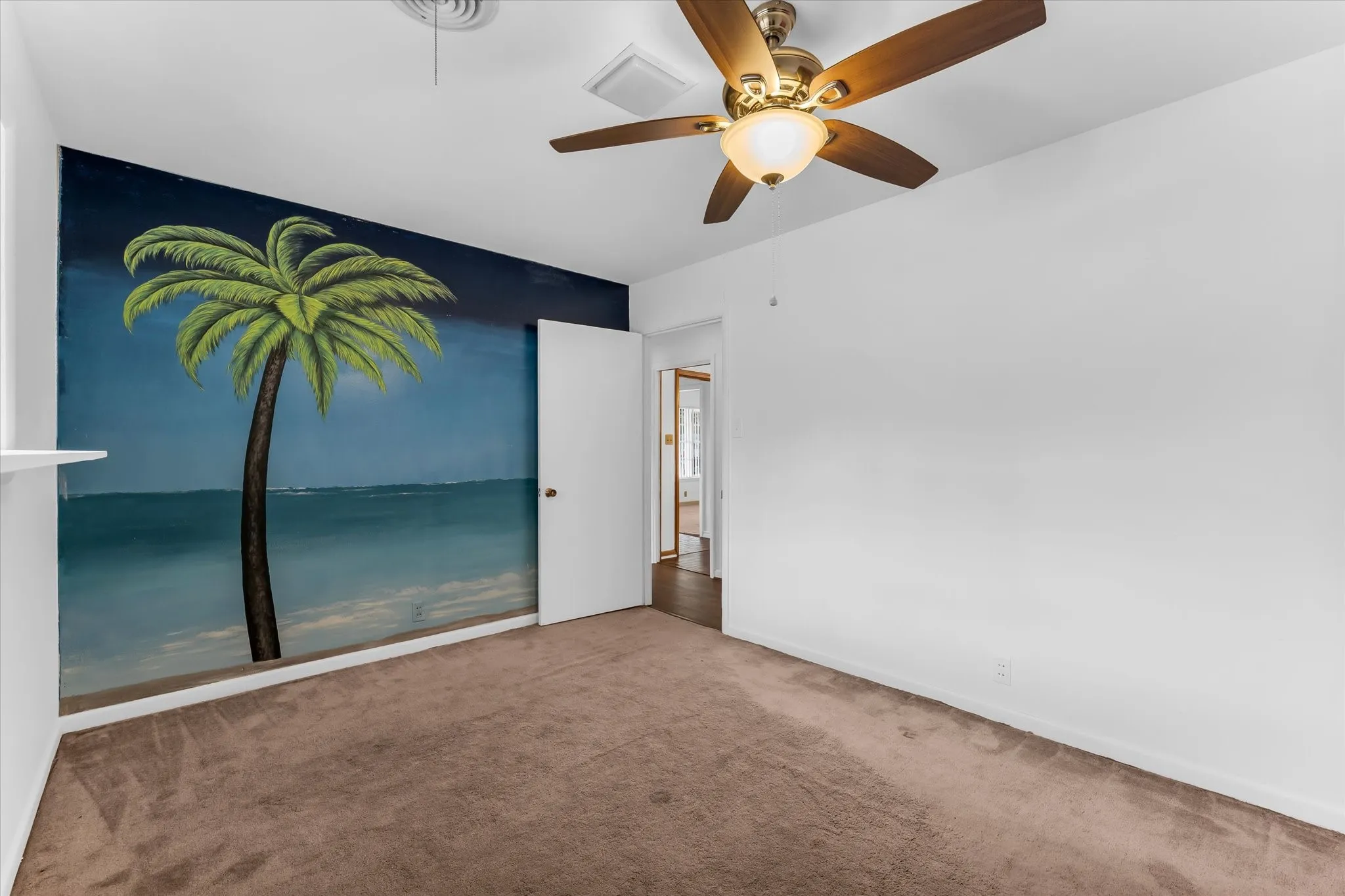 The middle bedroom is spacious with a custom beach mural.
