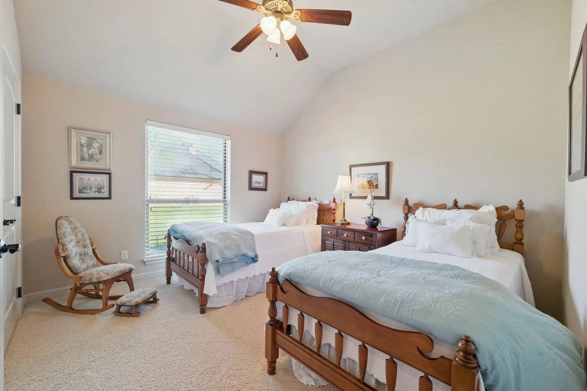 Vaulted ceiling with a ceiling fan, carpeted flooring, and a large window with blinds