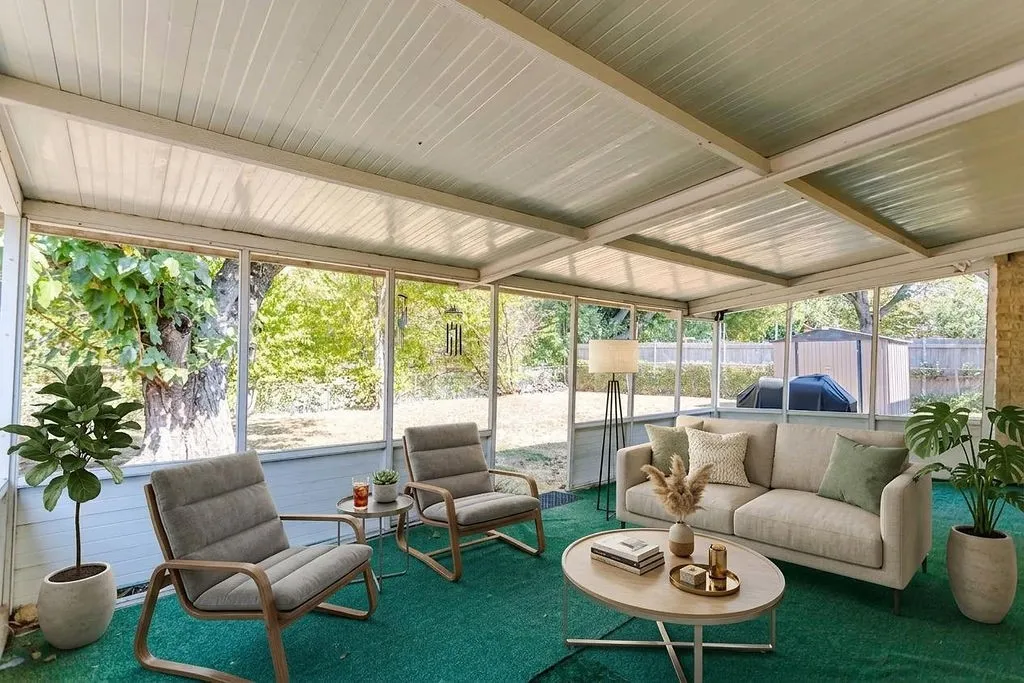 Enclosed sunroom with expansive windows, a white paneled ceiling, and a green floor