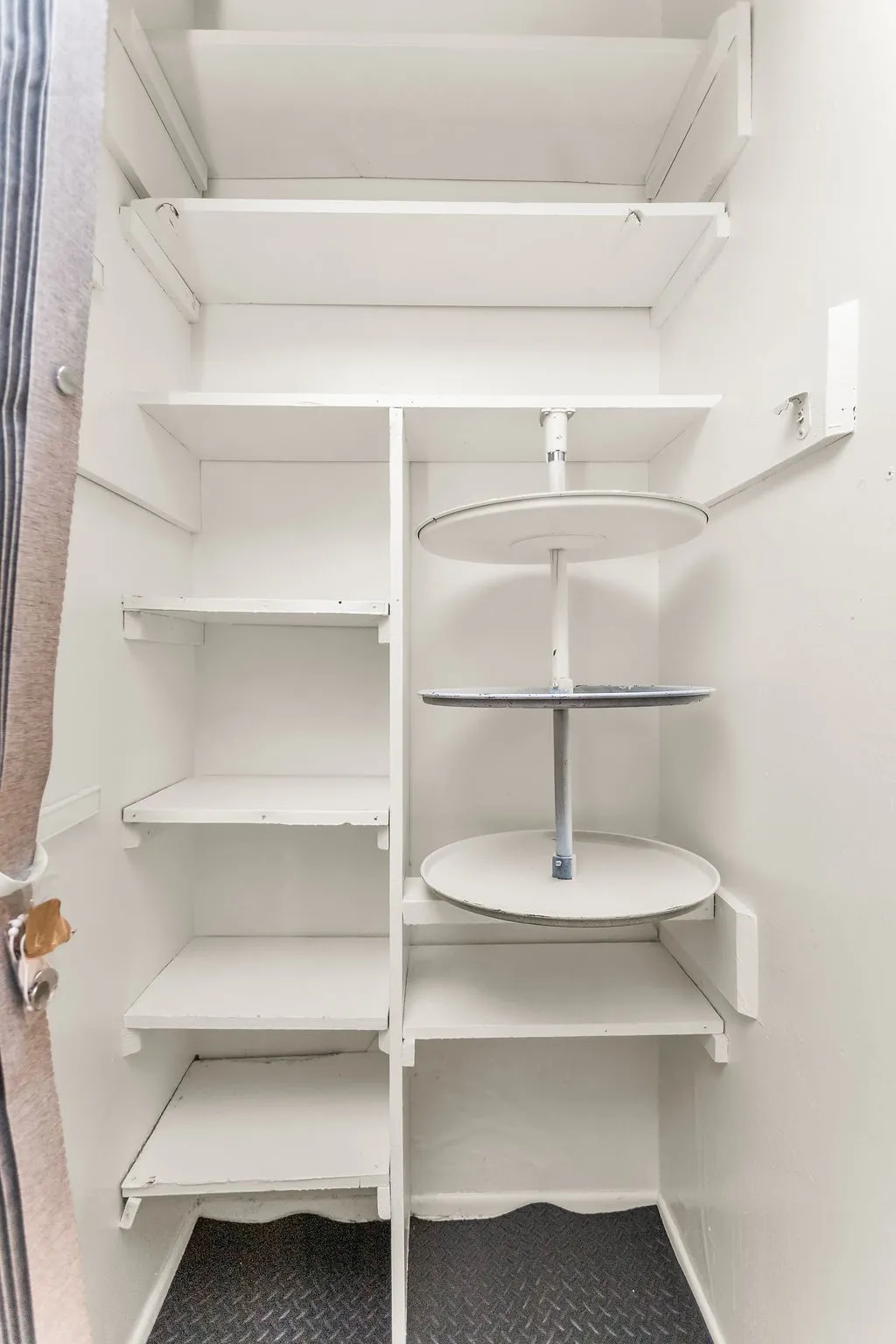 Built-in shelving with a corner lazy Susan unit and diamond-plate pattern flooring