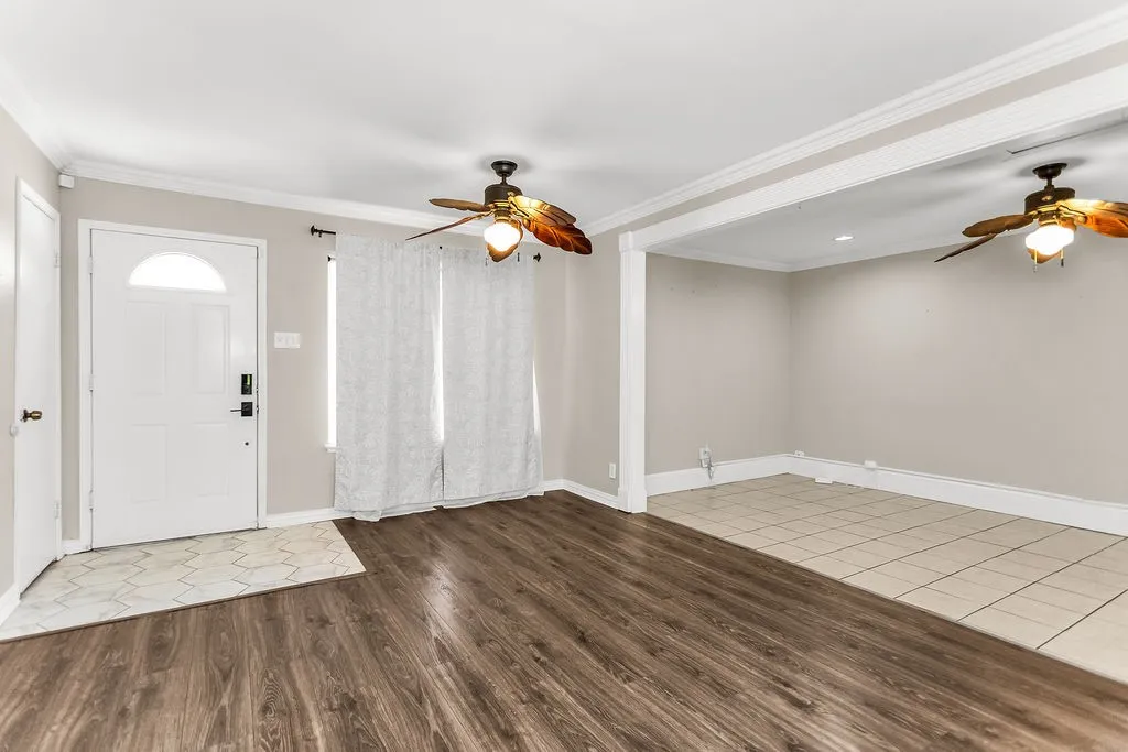 Wood-finish flooring, white trim, and ceiling fans